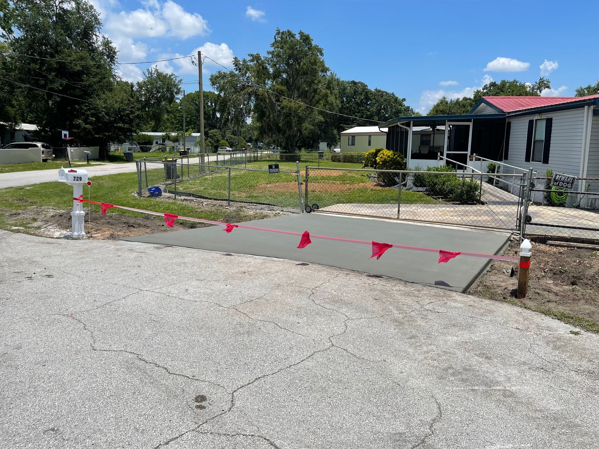 A concrete driveway is being built in front of a mobile home.