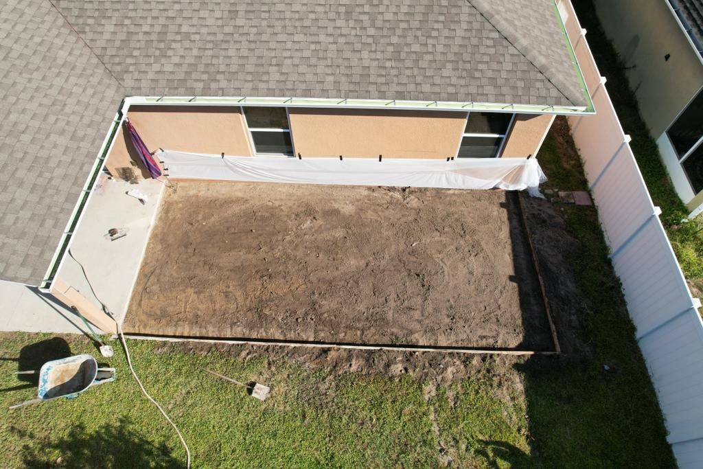 An aerial view of a house with a white fence in the backyard.