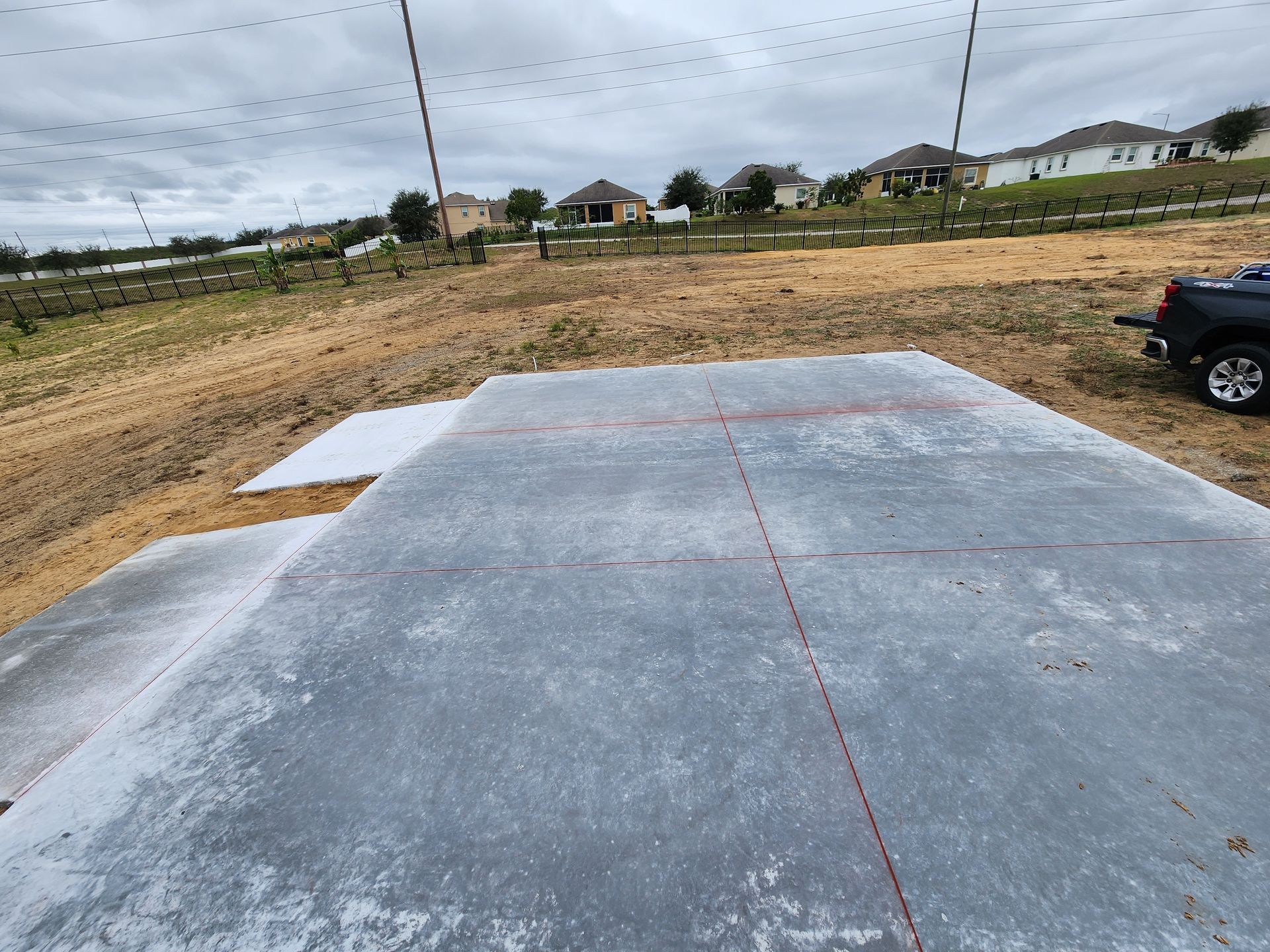 A truck is parked on the side of a concrete driveway.