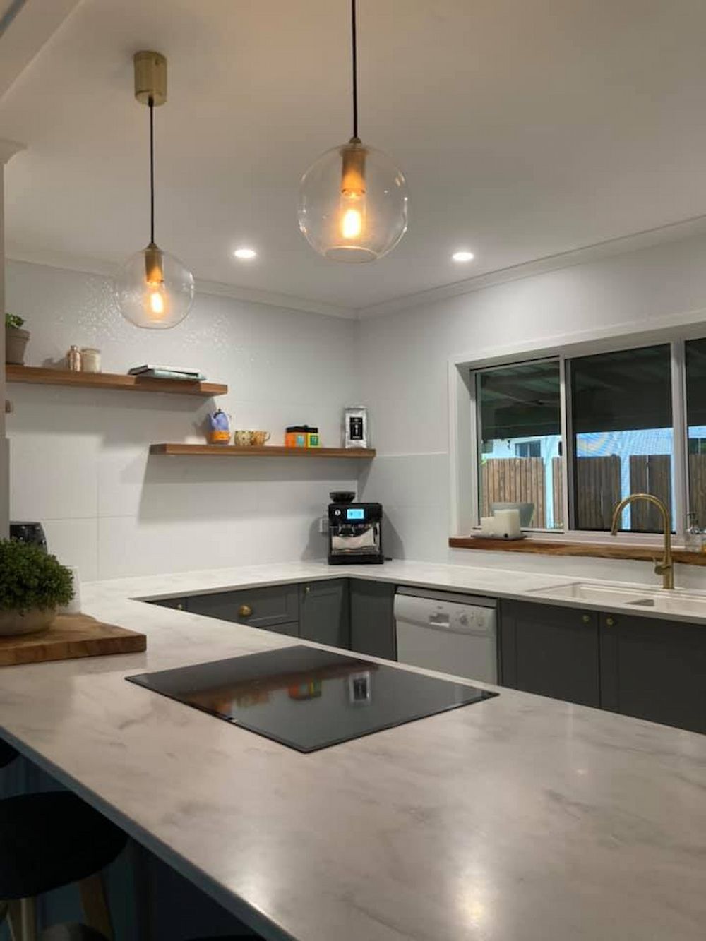 Modern Kitchen With a Marble Countertop, Gray Cabinets, and Floating Wooden Shelves — JGD Constructions in Lake Eacham, QLD