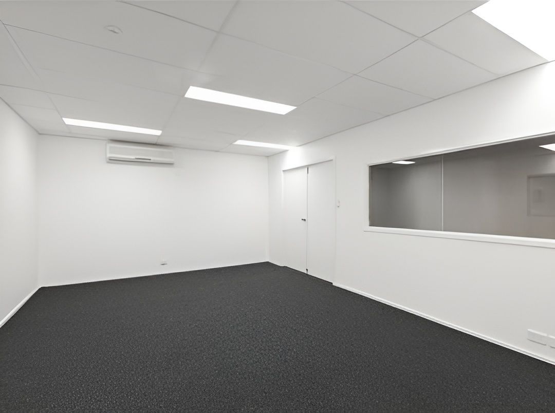 Empty Office Interior With White Walls, Gray Carpet, and a Window — JGD Constructions in Yungaburra, QLD