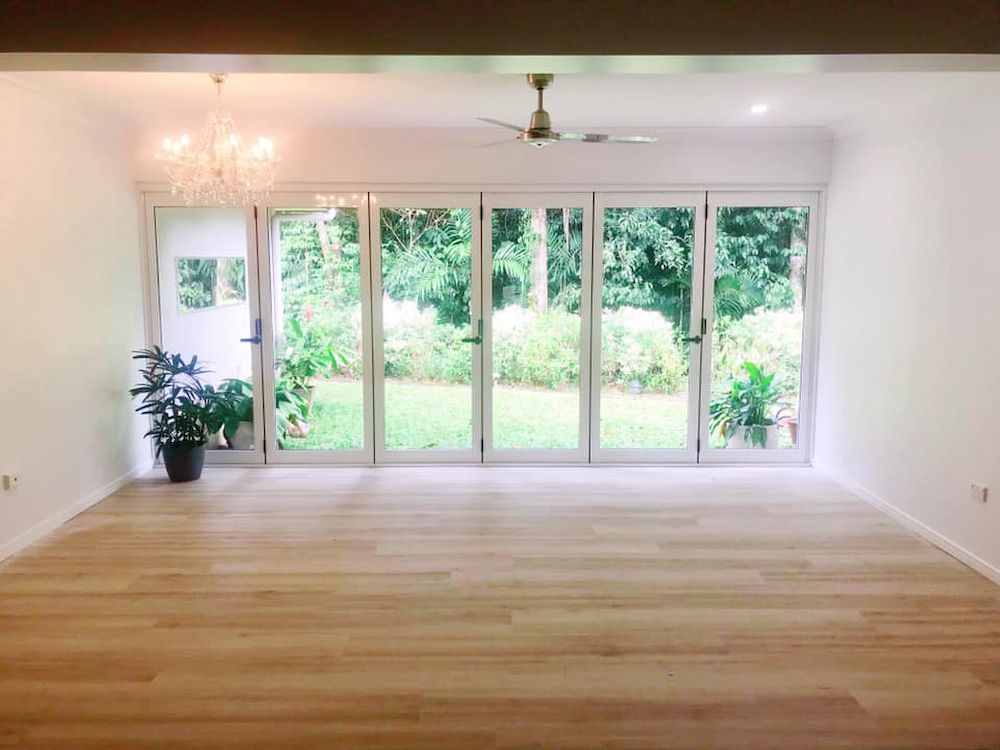 Empty, Bright Room With Light Wood Floors, Large Glass Doors — JGD Constructions in Atherton, QLD