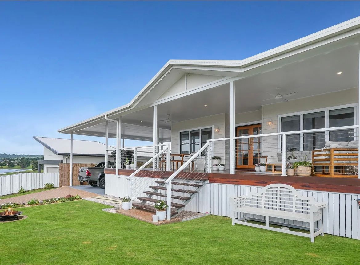 White House With Wraparound Porch And Steps Leading To The Front Door, Green Lawn, Blue Sky  — JGD Constructions in Atherton, QLD