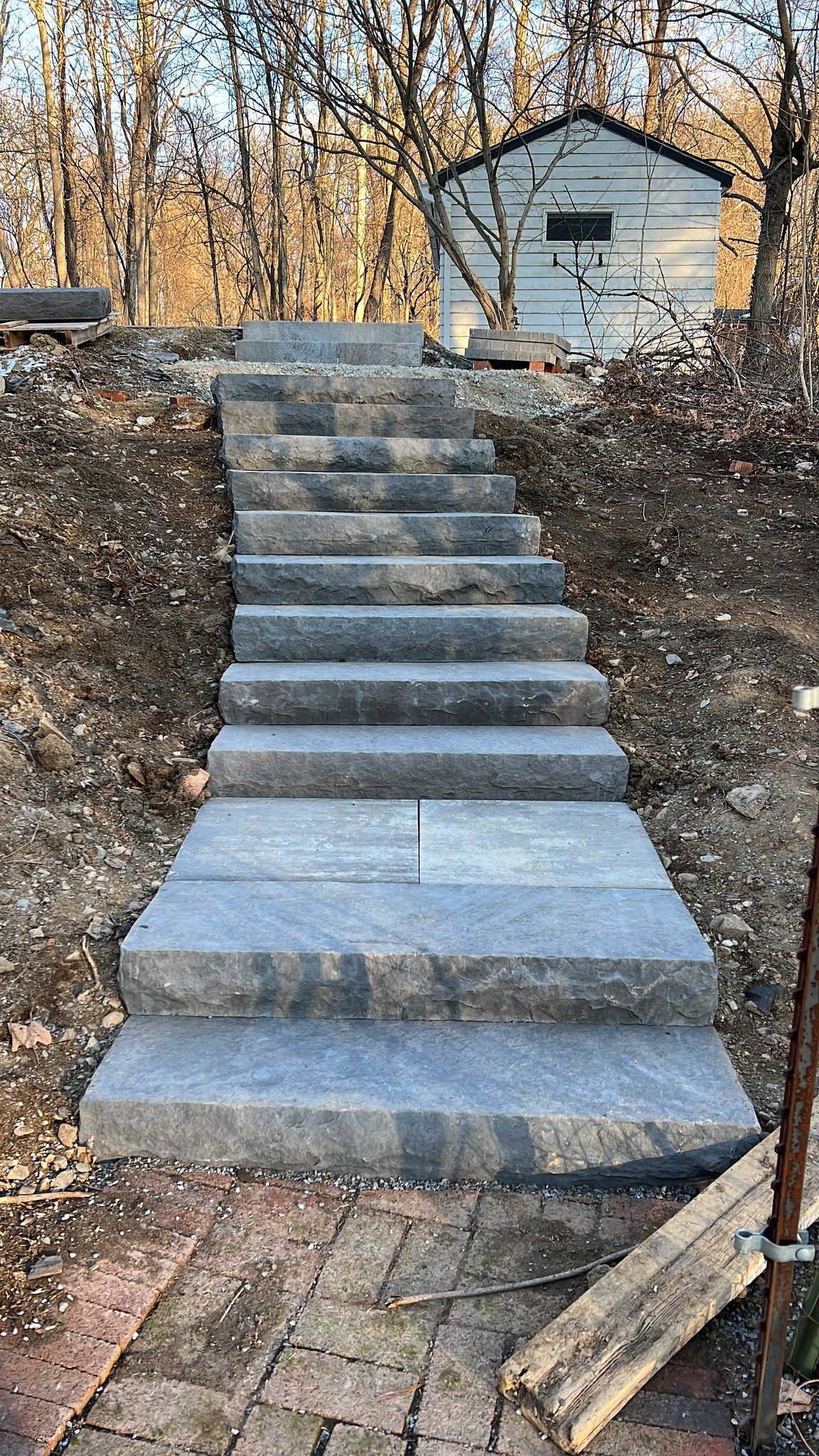 Stone steps leading up a hill toward a small white building.