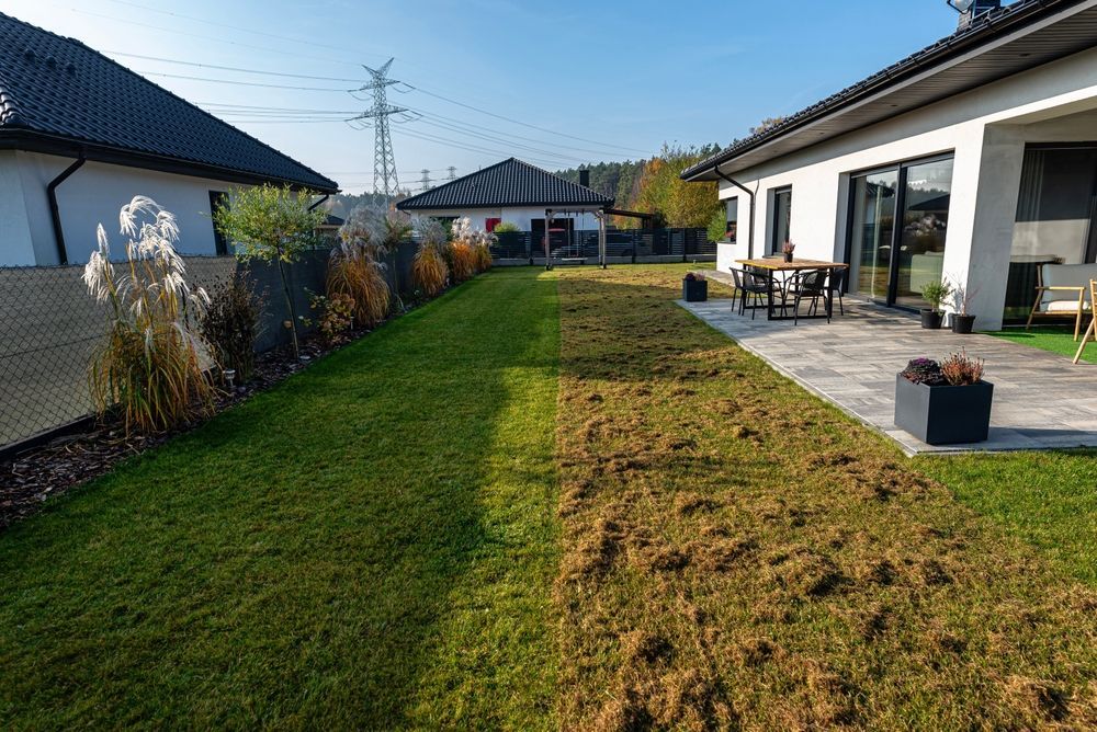 A house with a large lawn and a patio in front of it.