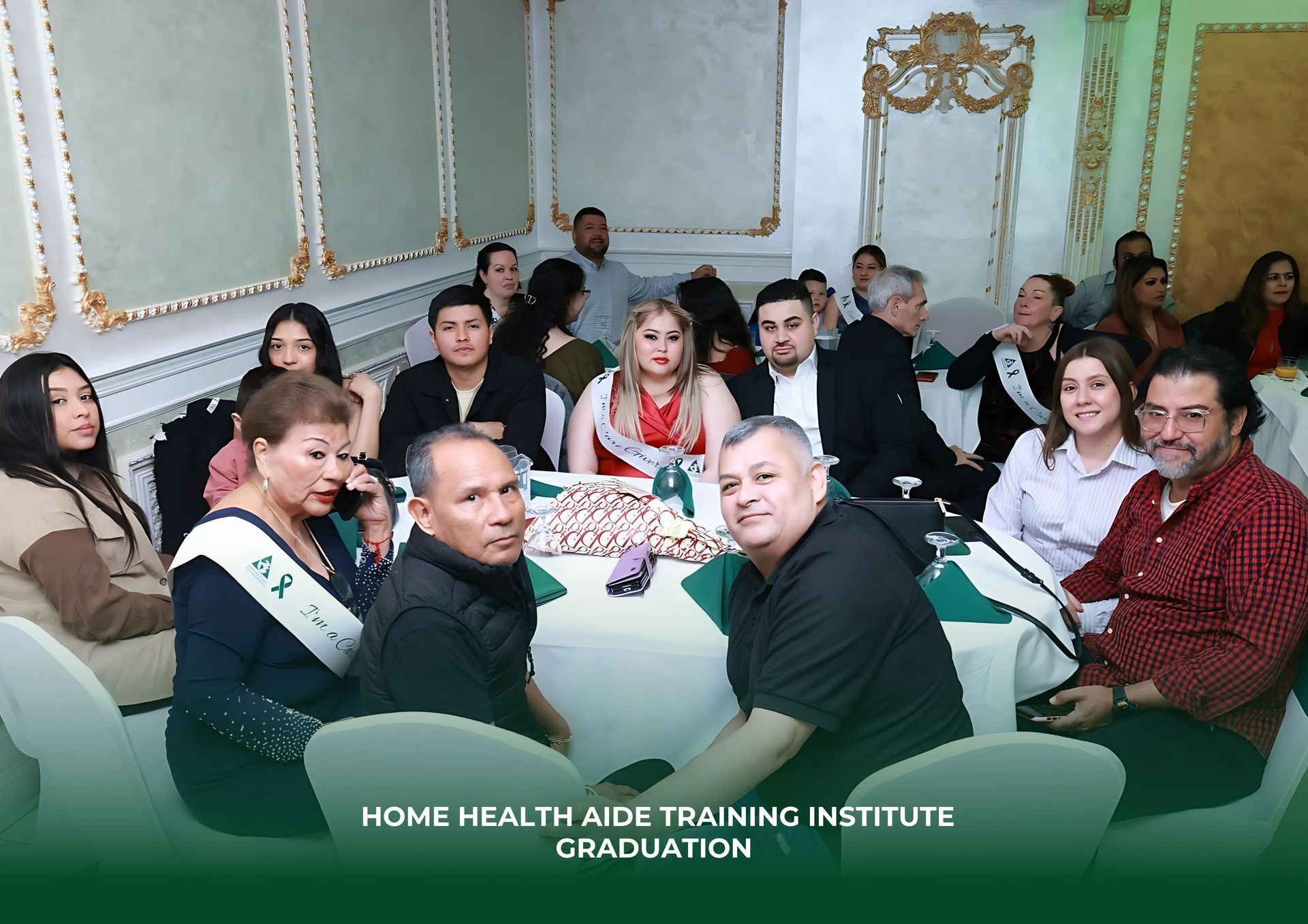 A group of people are sitting around a table at a home health aide training institute graduation.