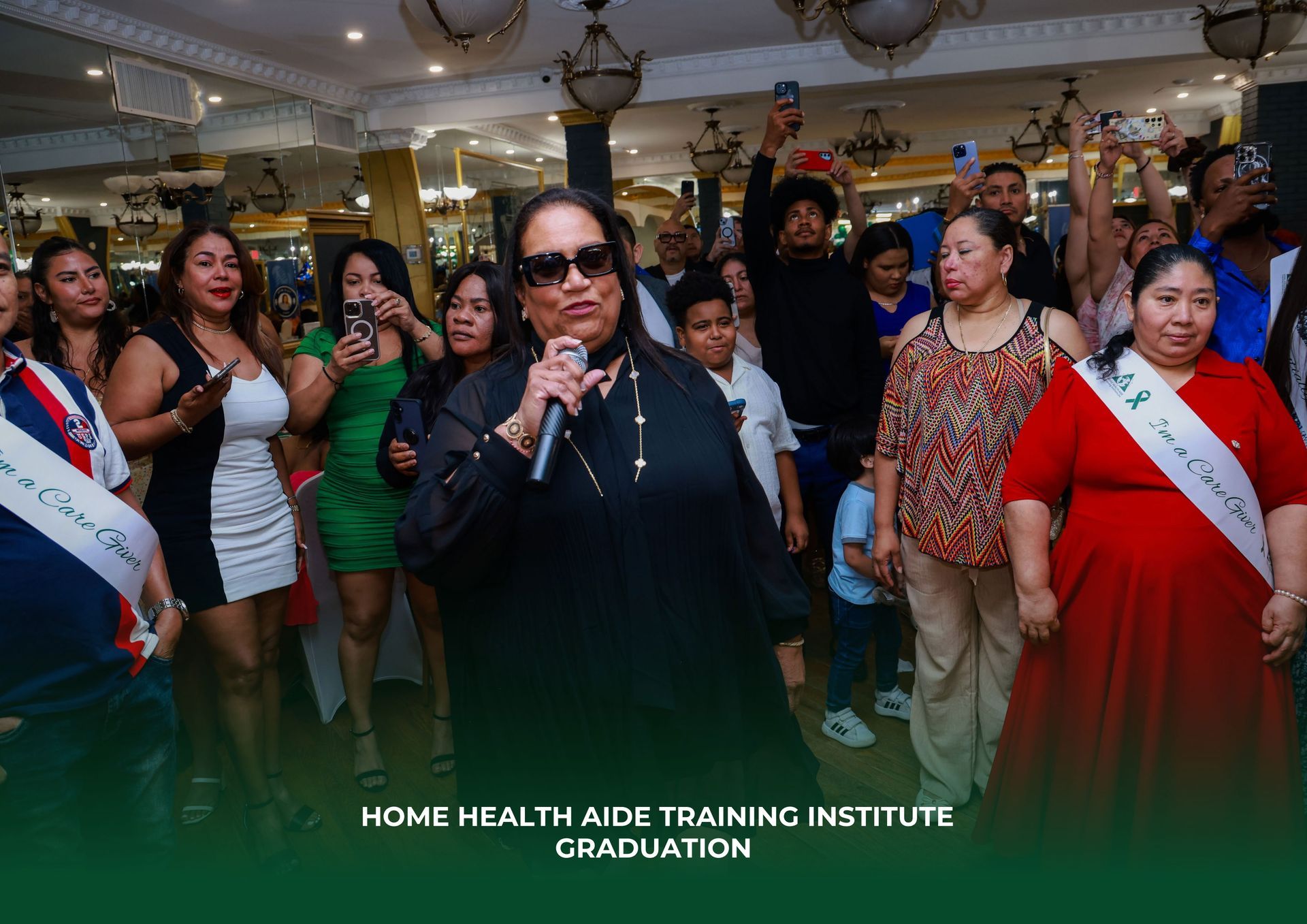 A woman is holding a microphone in front of a crowd of people at a graduation party.