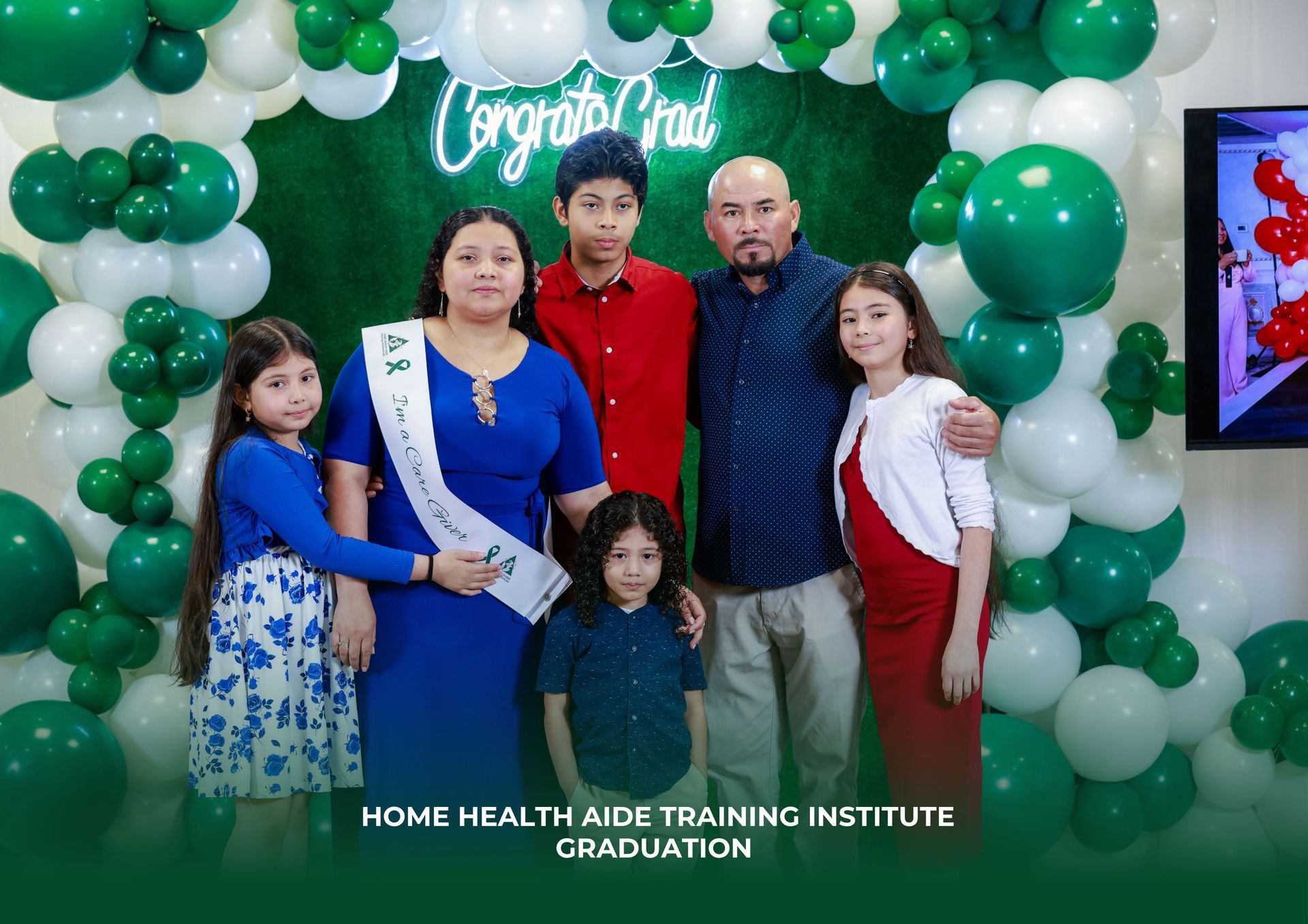 A family is posing for a picture in front of balloons.