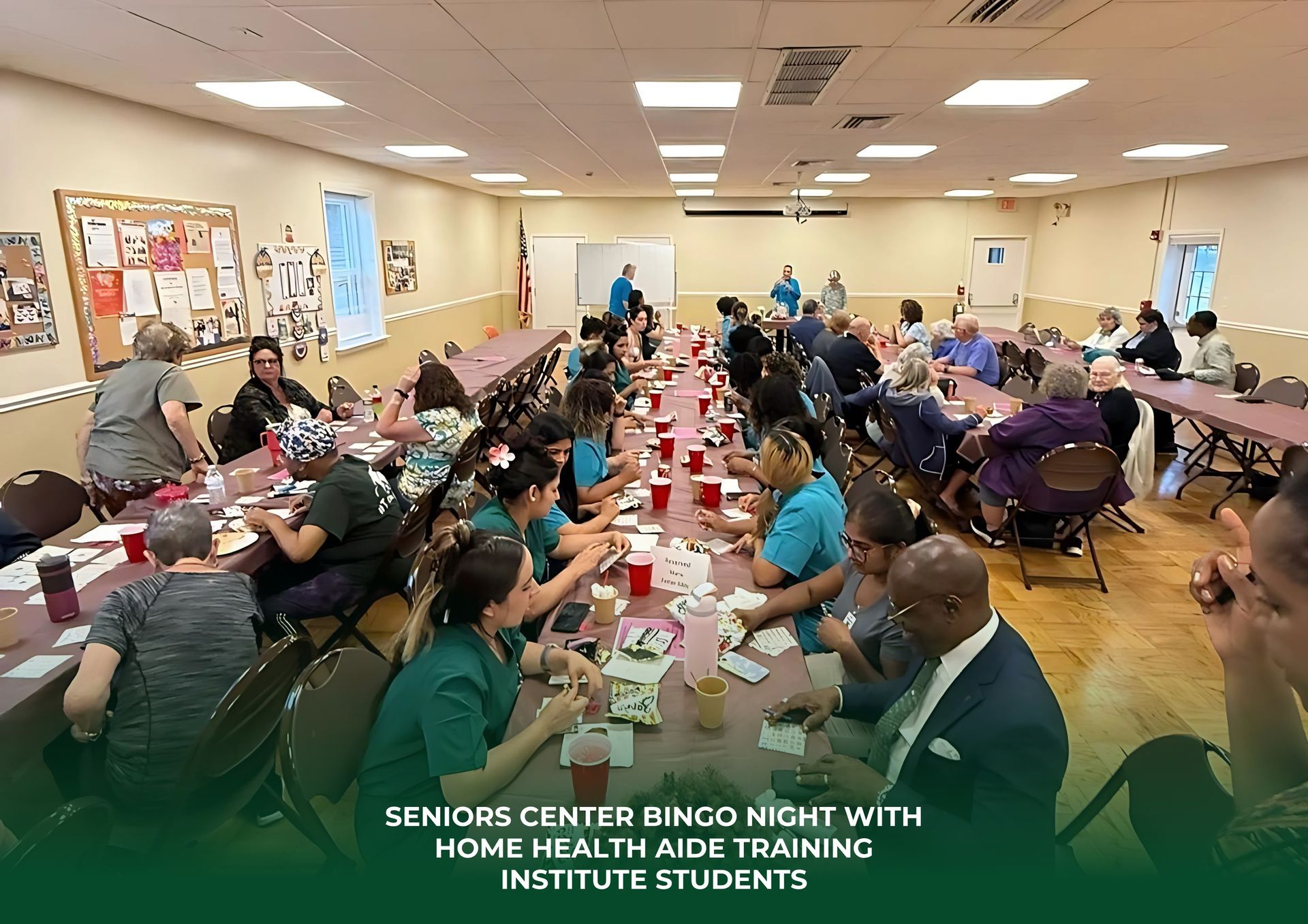 A large group of people are sitting at long tables in a room.