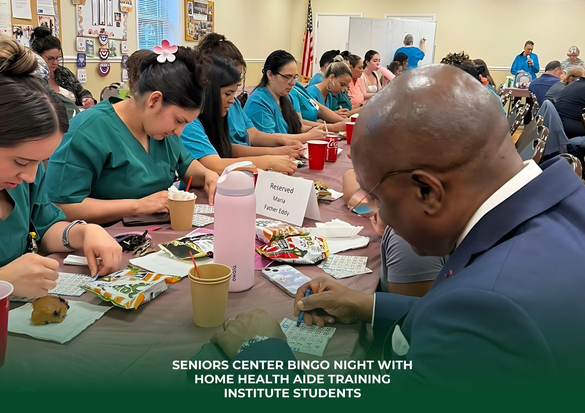 A group of people are sitting at a table with a man in a suit.