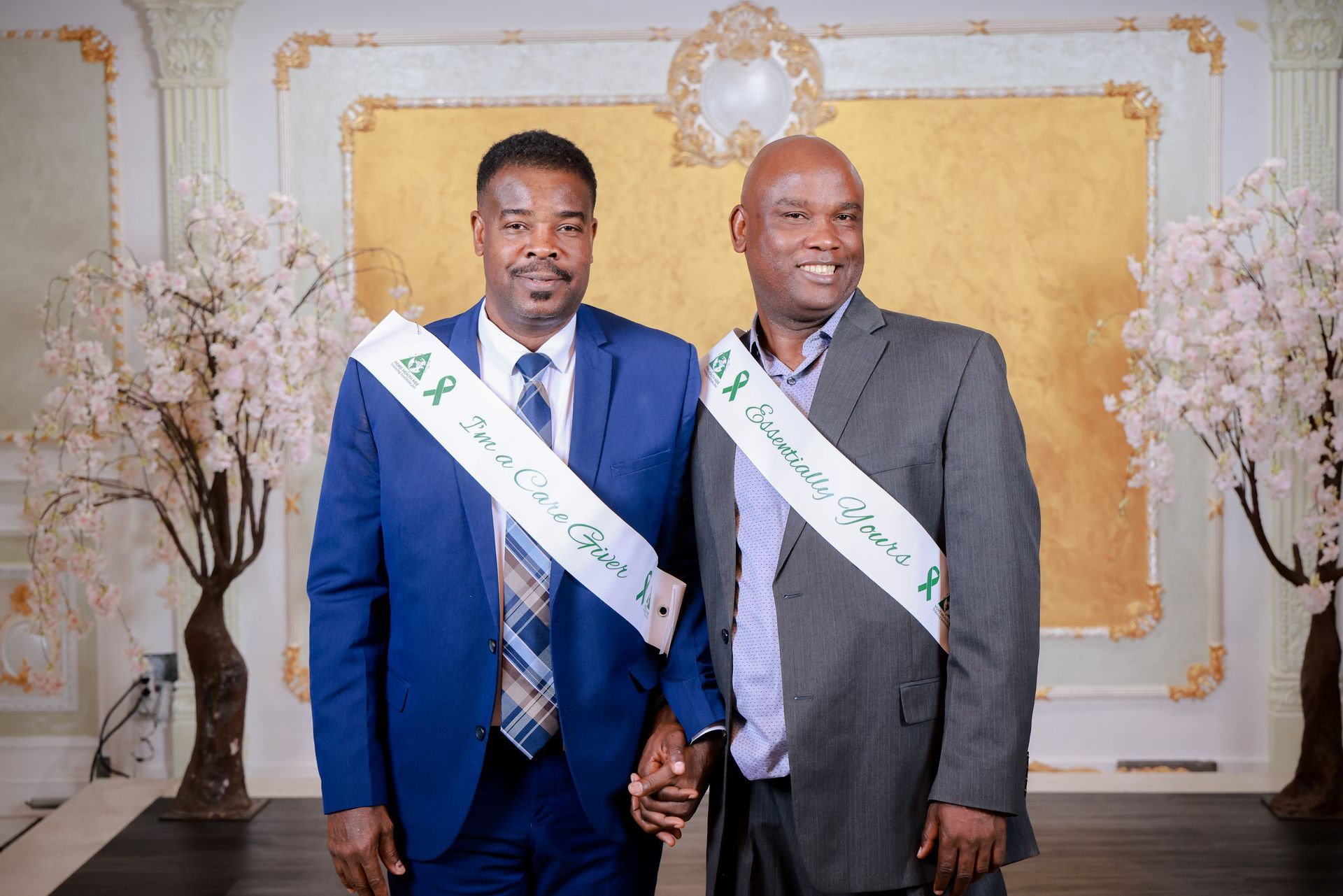 Two men in suits and ties are standing next to each other holding hands.