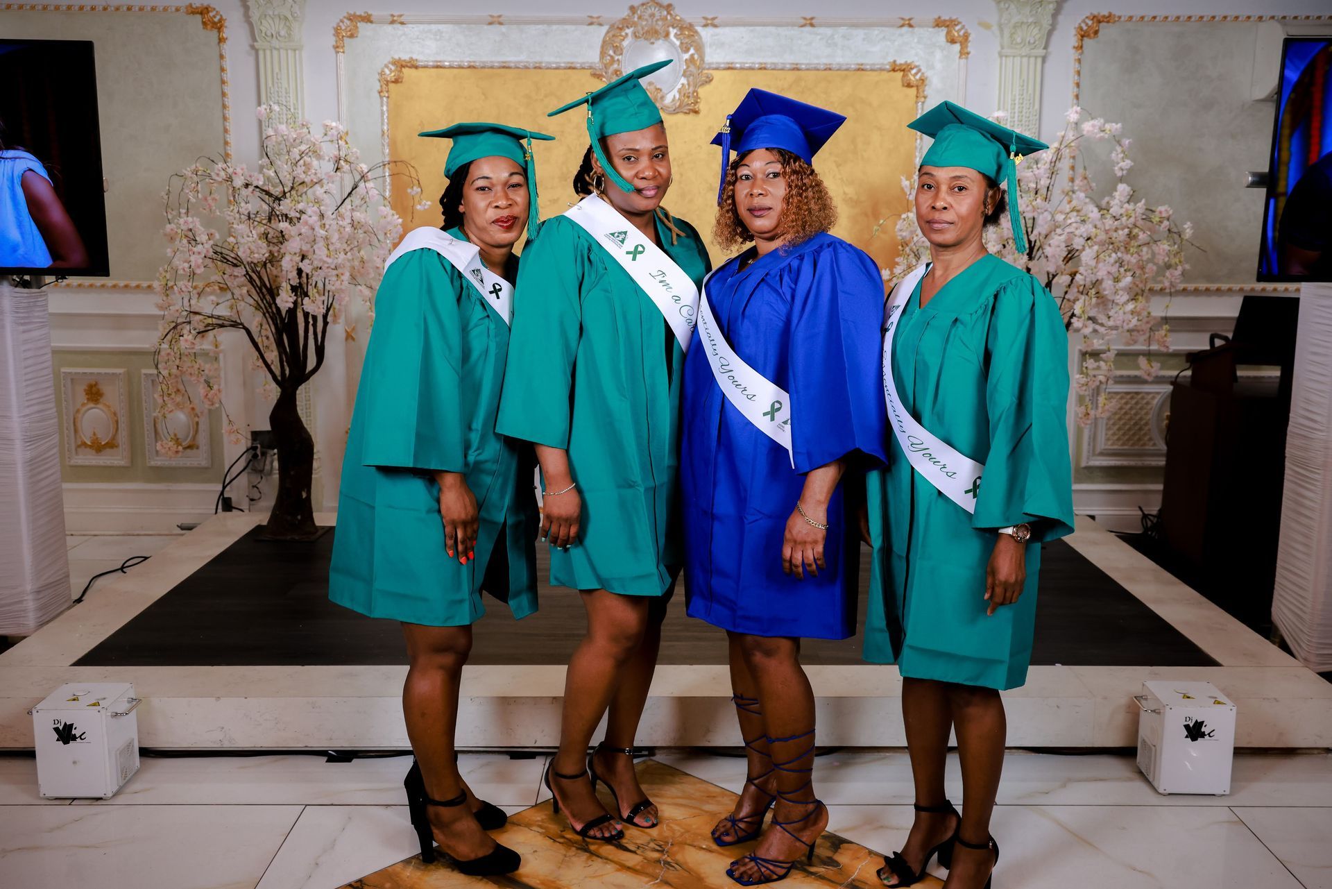 A group of women in graduation gowns are posing for a picture.