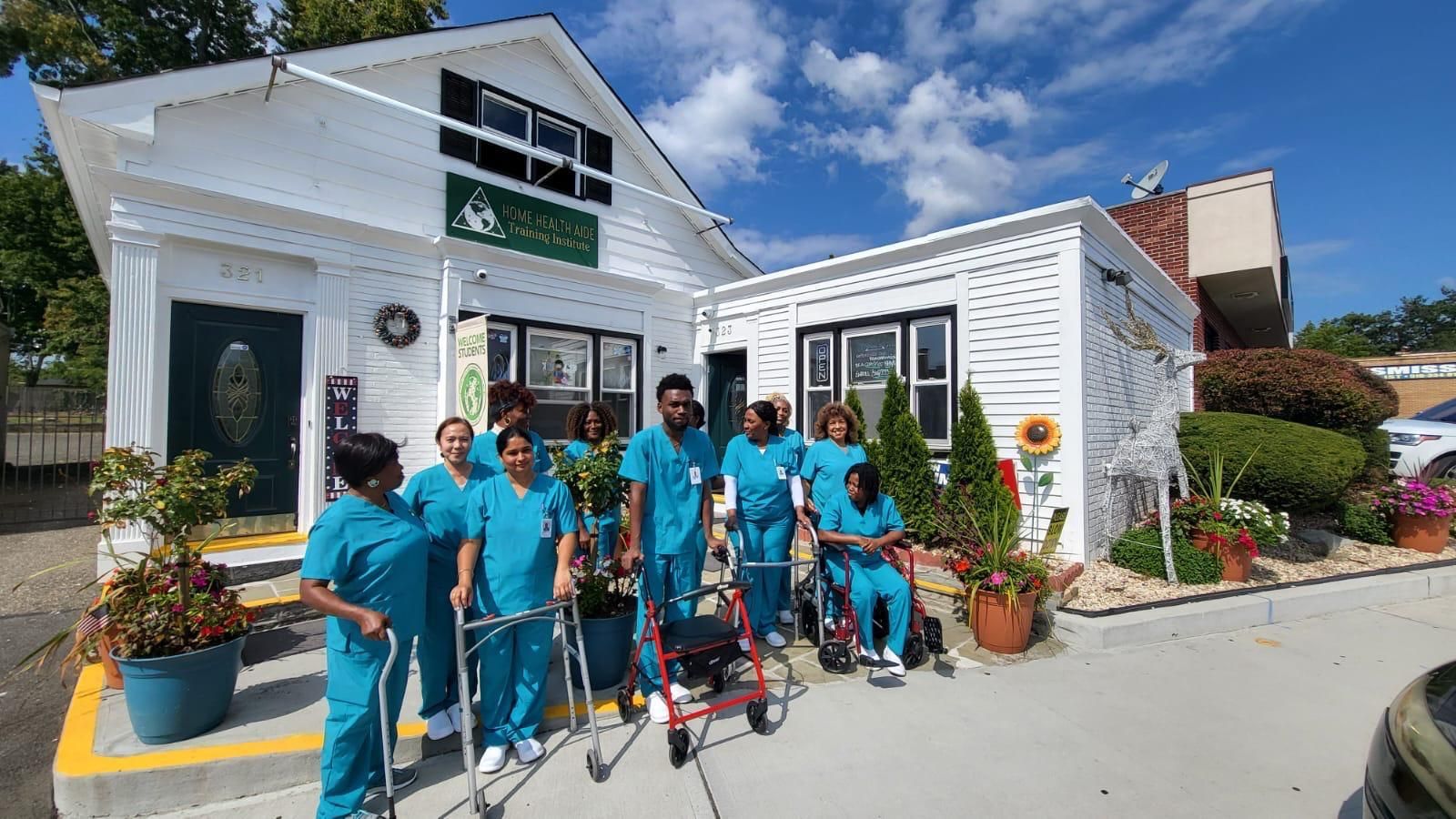 An instructor guides a group of nursing students in scrubs as they practice using a patient lift with a mannequin.