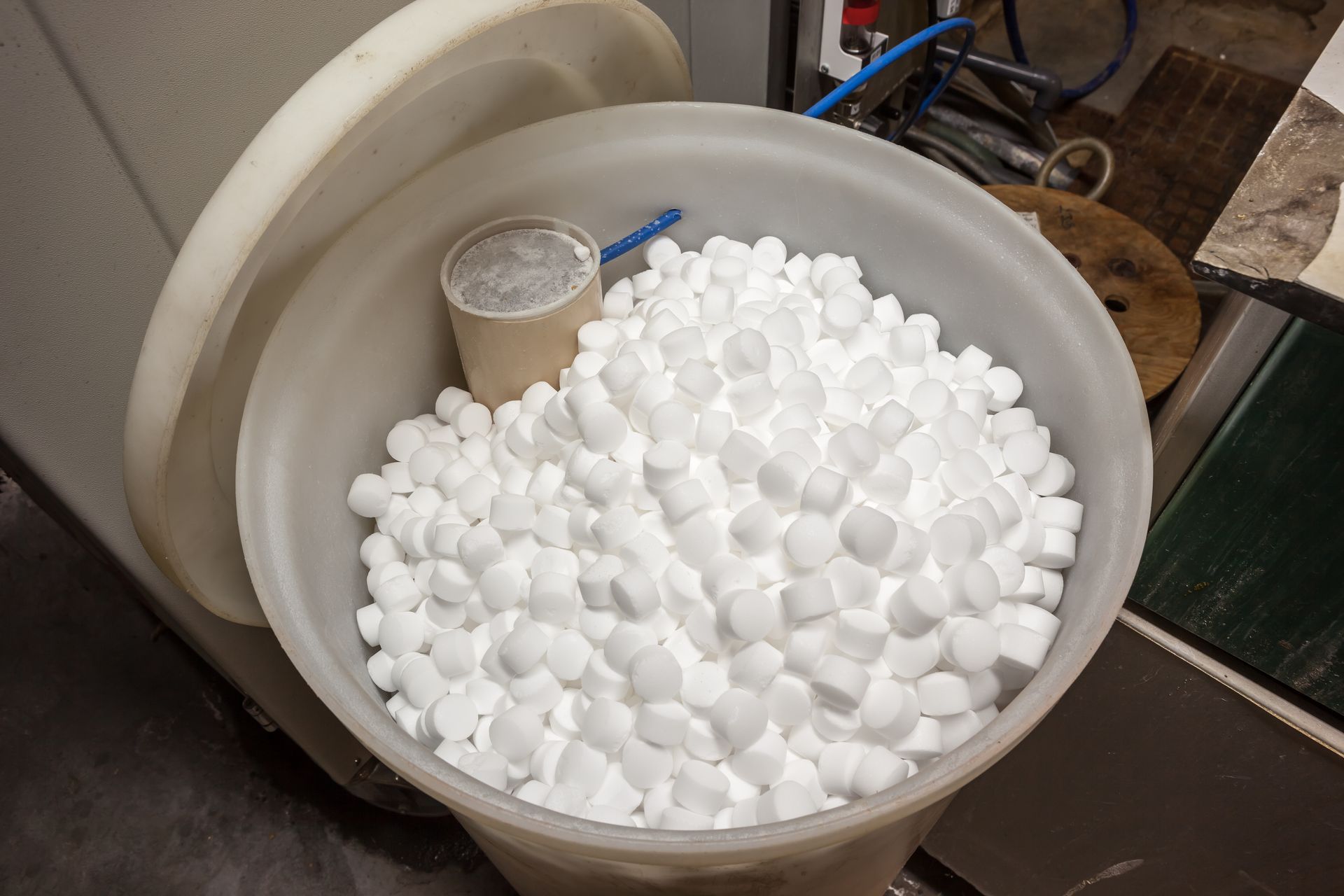 A plastic container filled with white balls and a cup