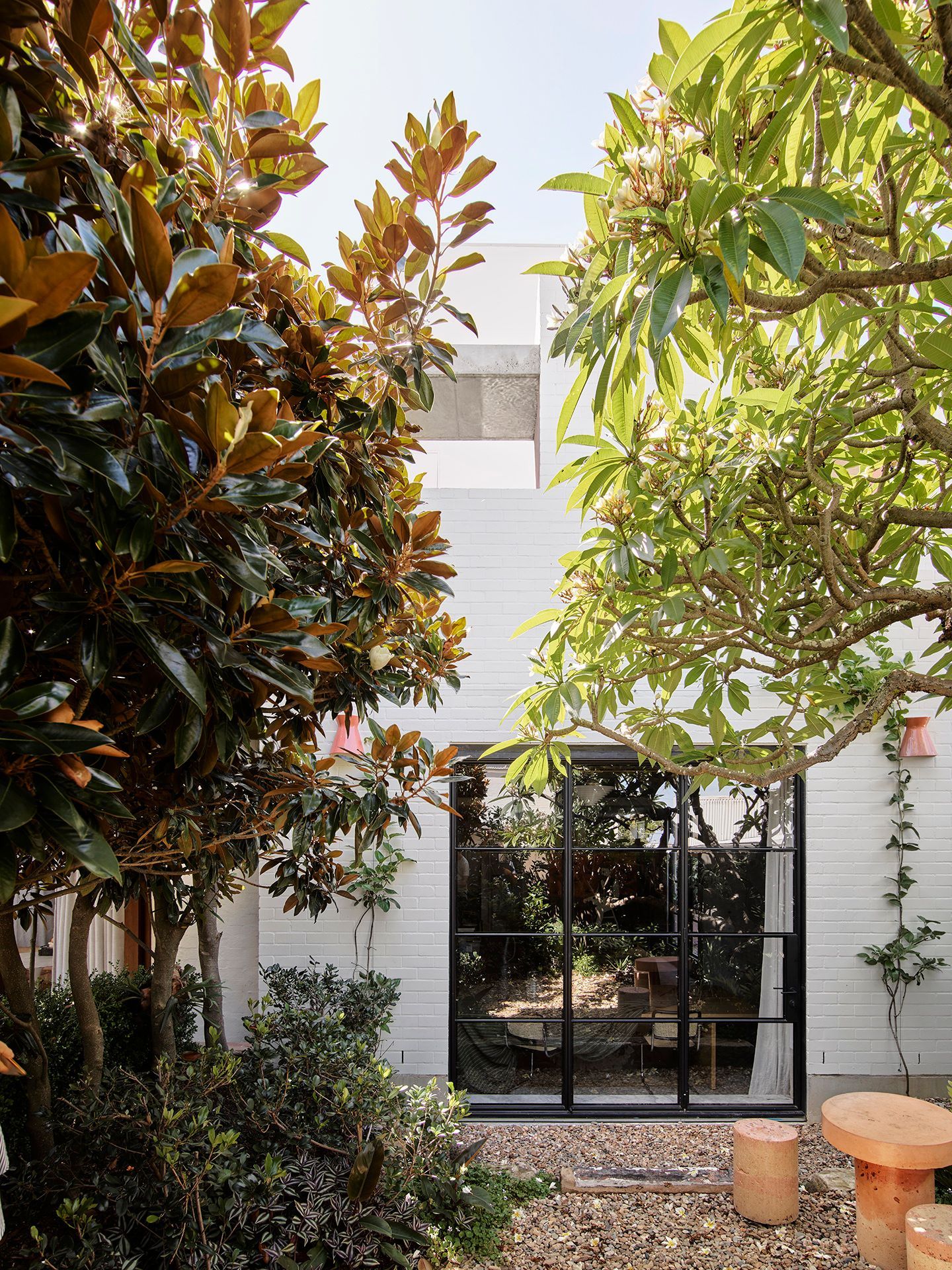 A white house with a lot of trees in front of it.