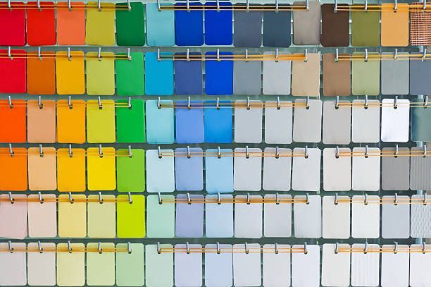 A bunch of different colored paint samples are hanging on a wall.