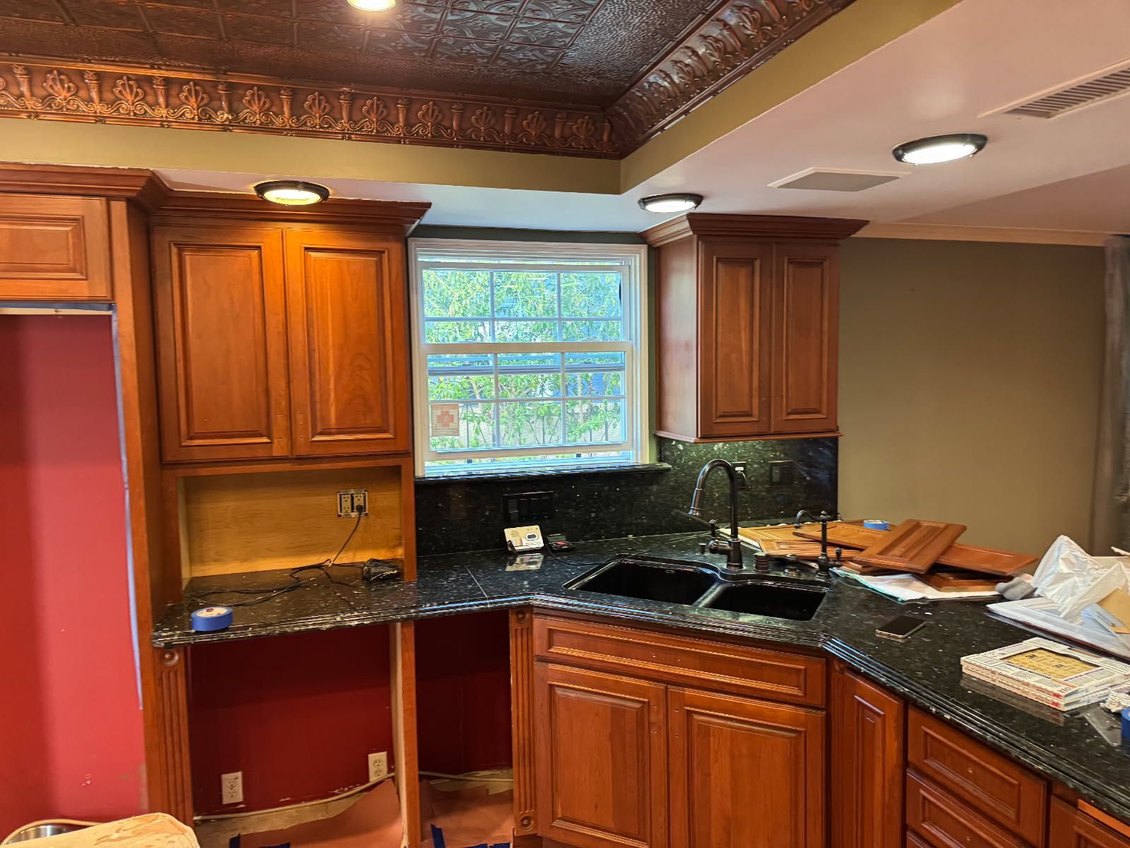 A kitchen with wooden cabinets and granite counter tops is being remodeled.