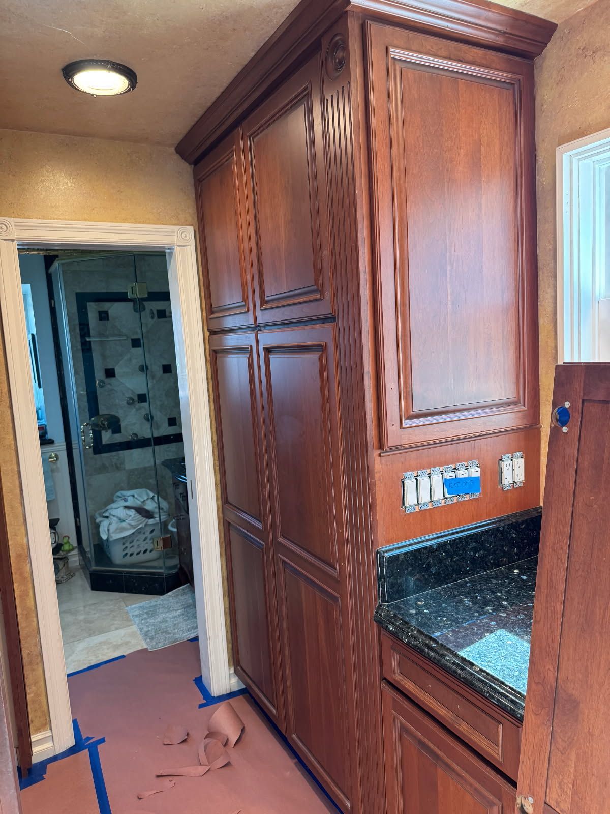 A bathroom with wooden cabinets and a black counter top