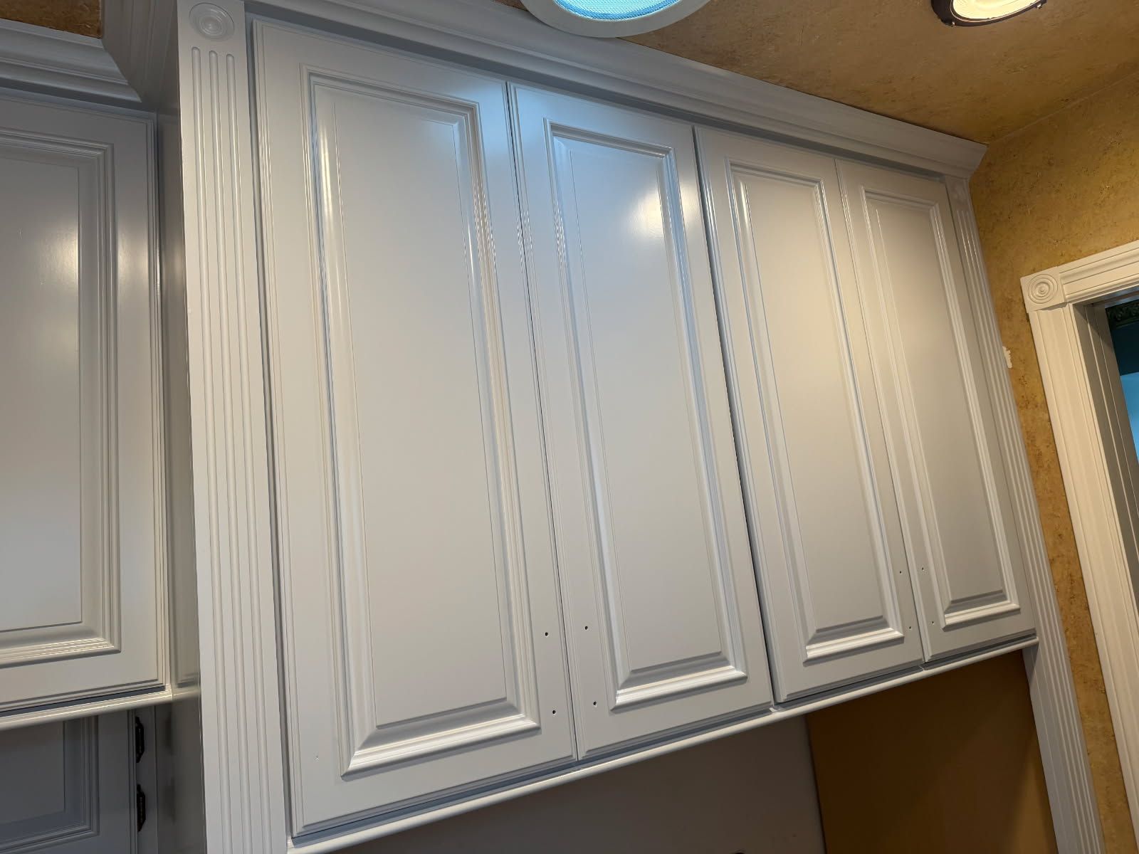 A kitchen with white cabinets and a light on the ceiling.