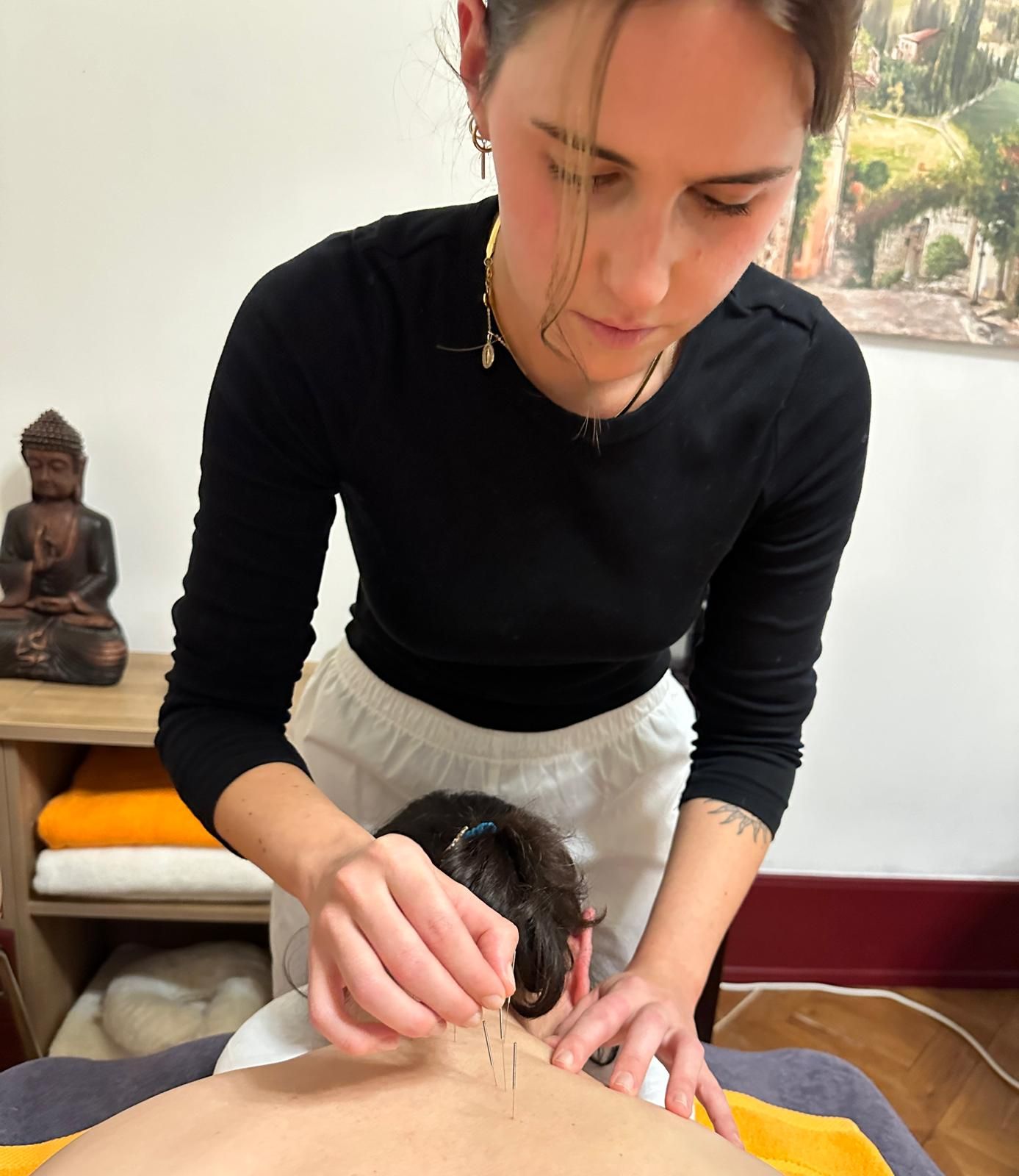 Eine Frau gibt einem Mann eine Akupunkturbehandlung