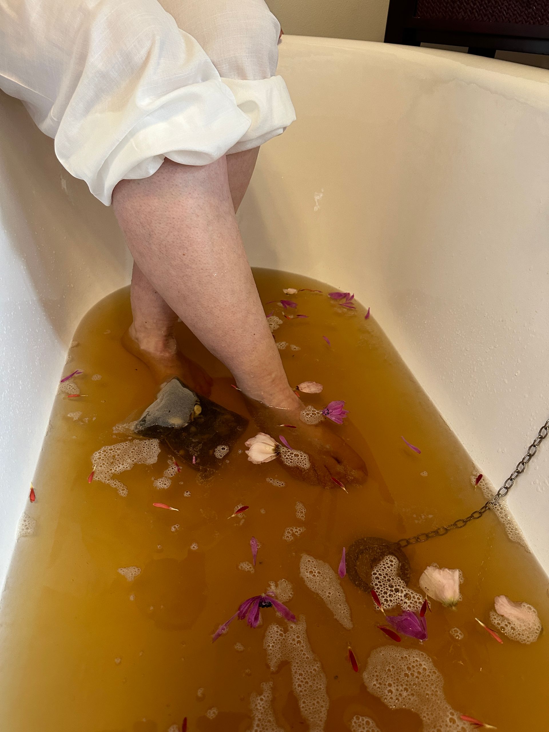 Eine Person nimmt ein Bad und hat dabei ihre Füße im Wasser.