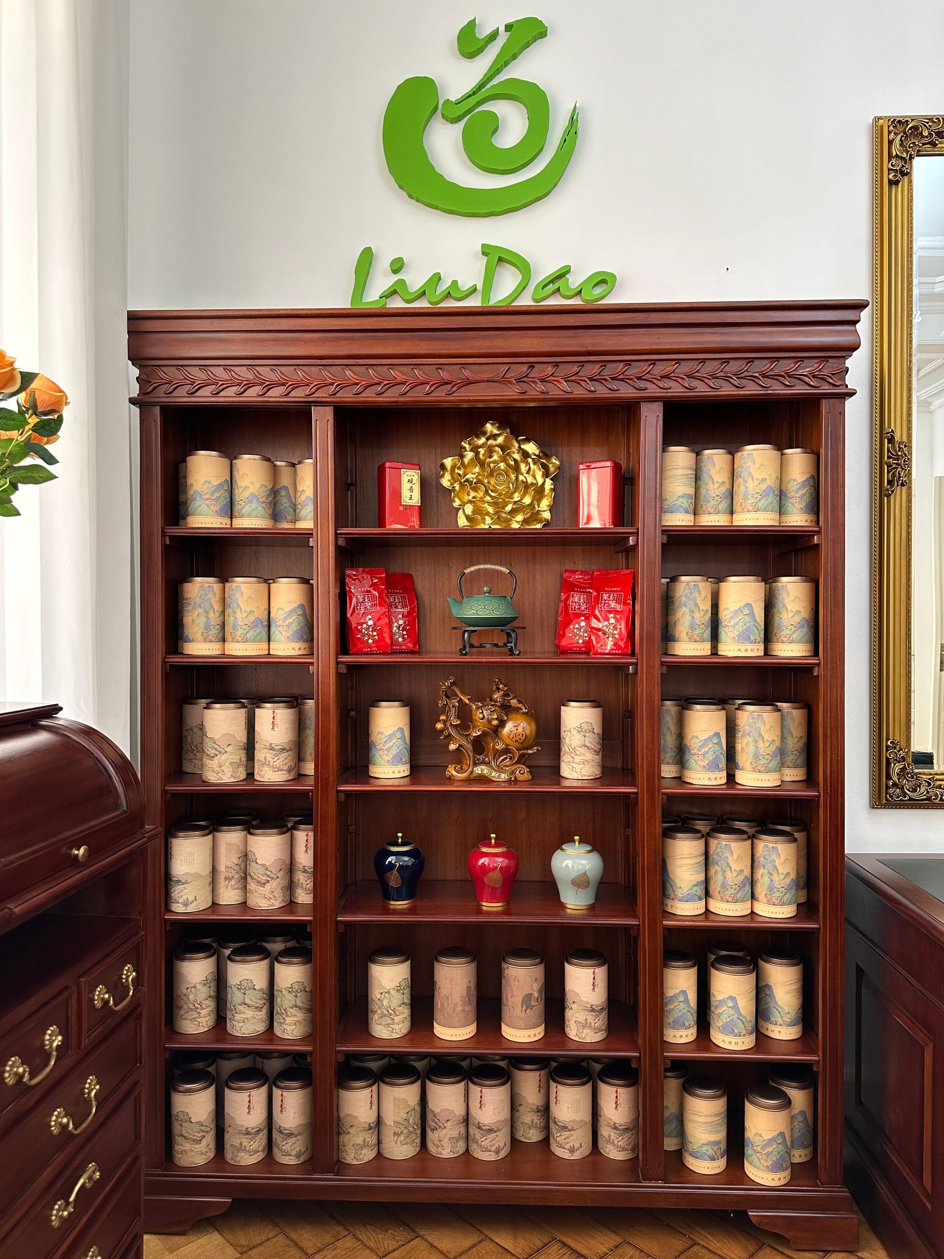 Ein Bücherregal mit einem grünen Logo an der Wand darüber