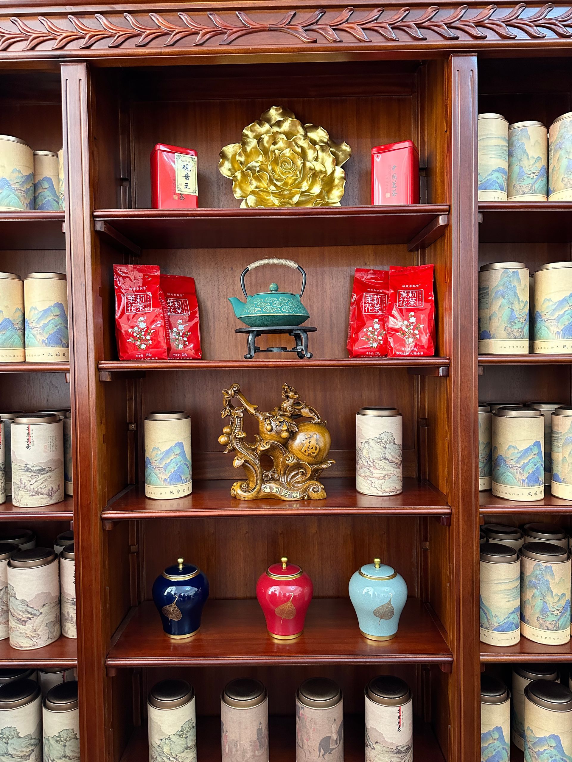 Ein Holzregal voller Gläser und Vasen.