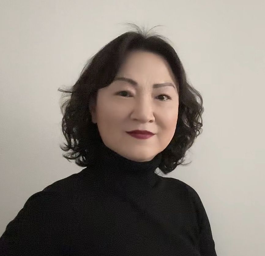 Die Frau trägt einen schwarzen Rollkragenpullover und roten Lippenstift