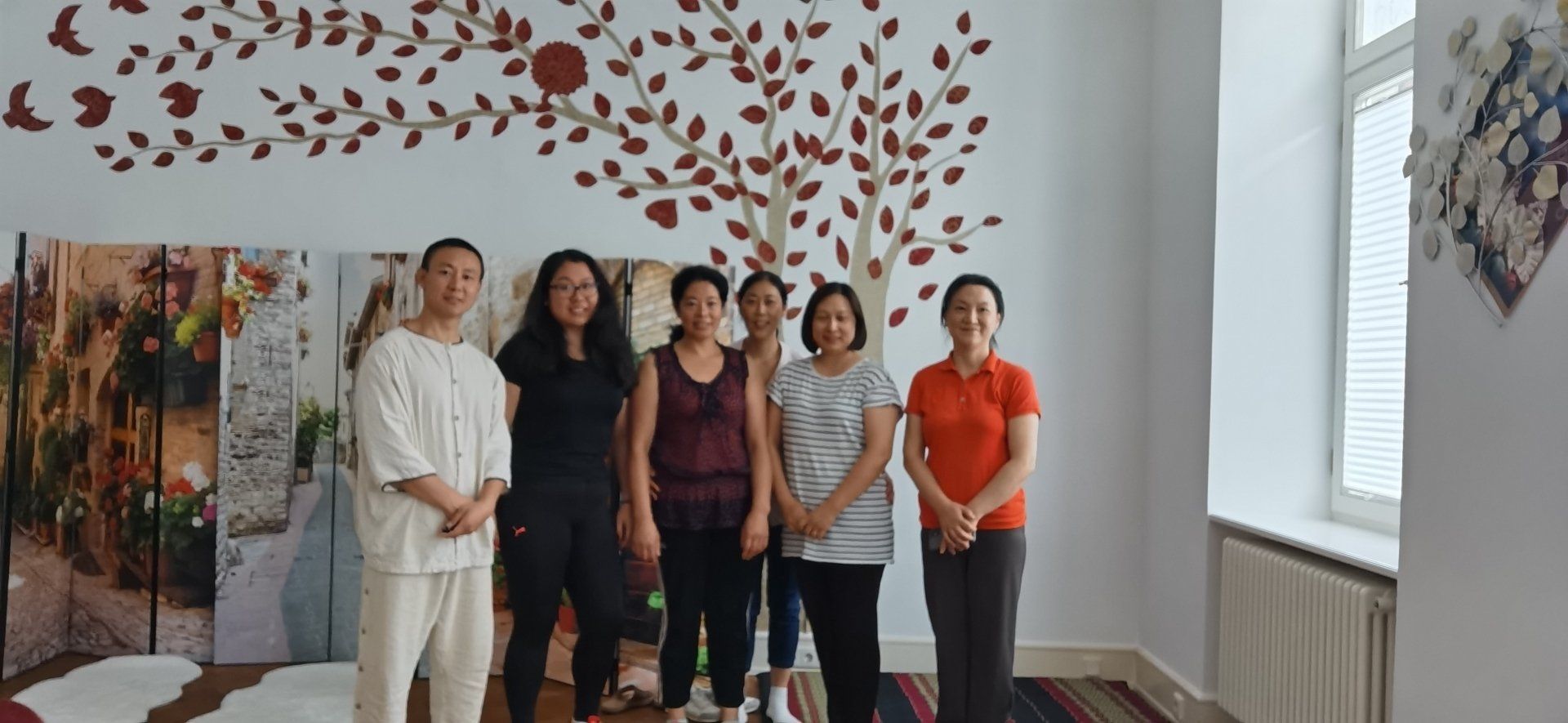 Eine Gruppe von Leuten steht in einem Raum mit einem Baum an der Wand.