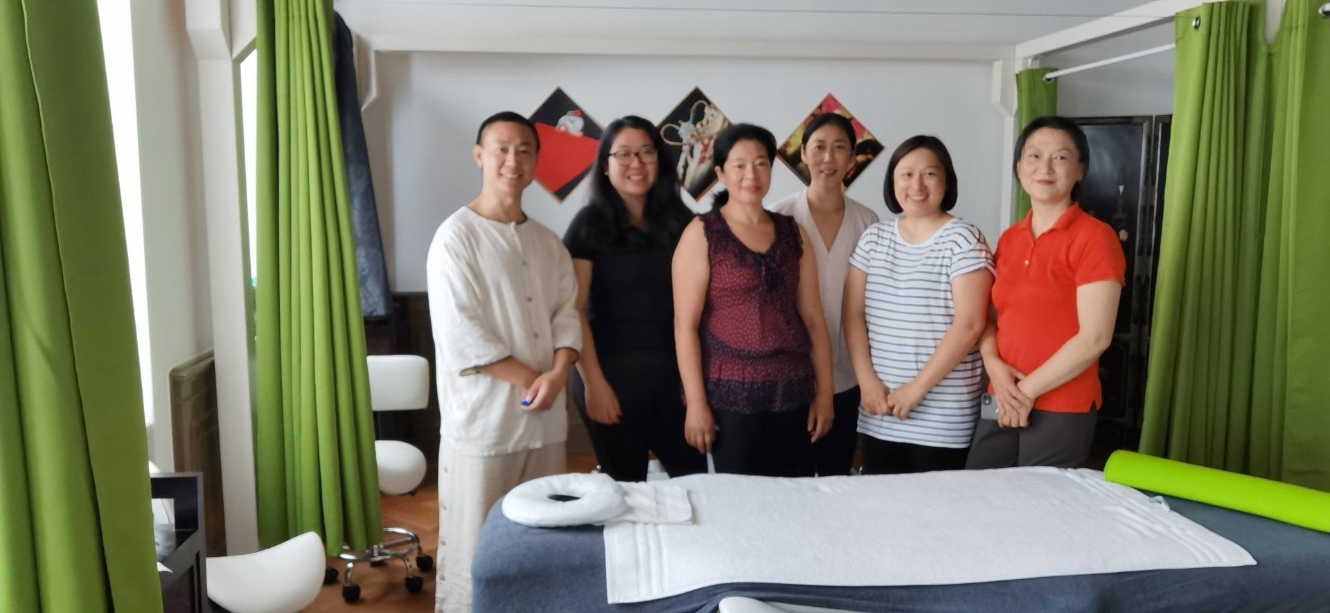 Eine Gruppe von Frauen steht vor einem Massagetisch.