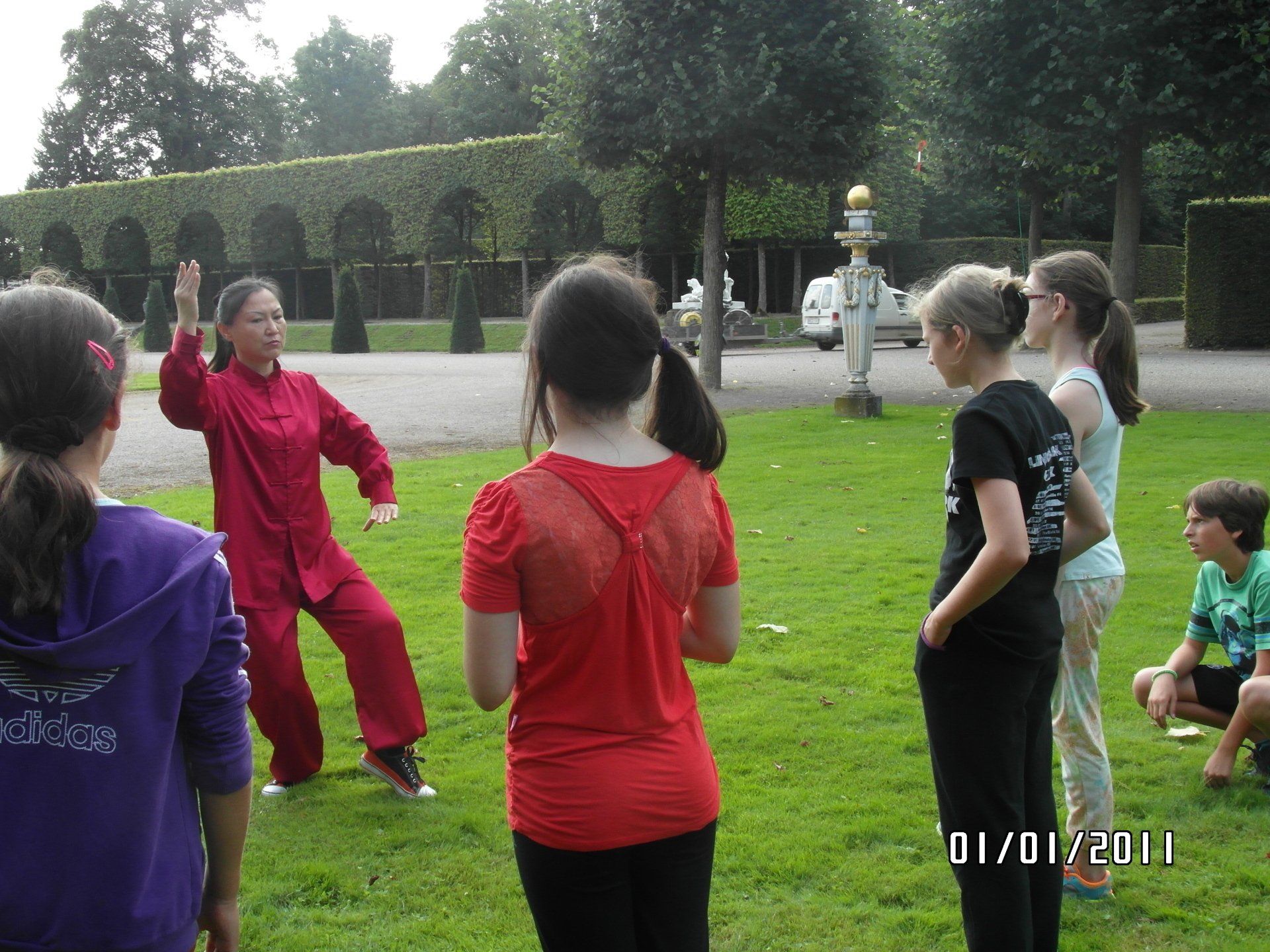 Ein Mädchen in einem roten Hemd steht vor einer Gruppe von Kindern