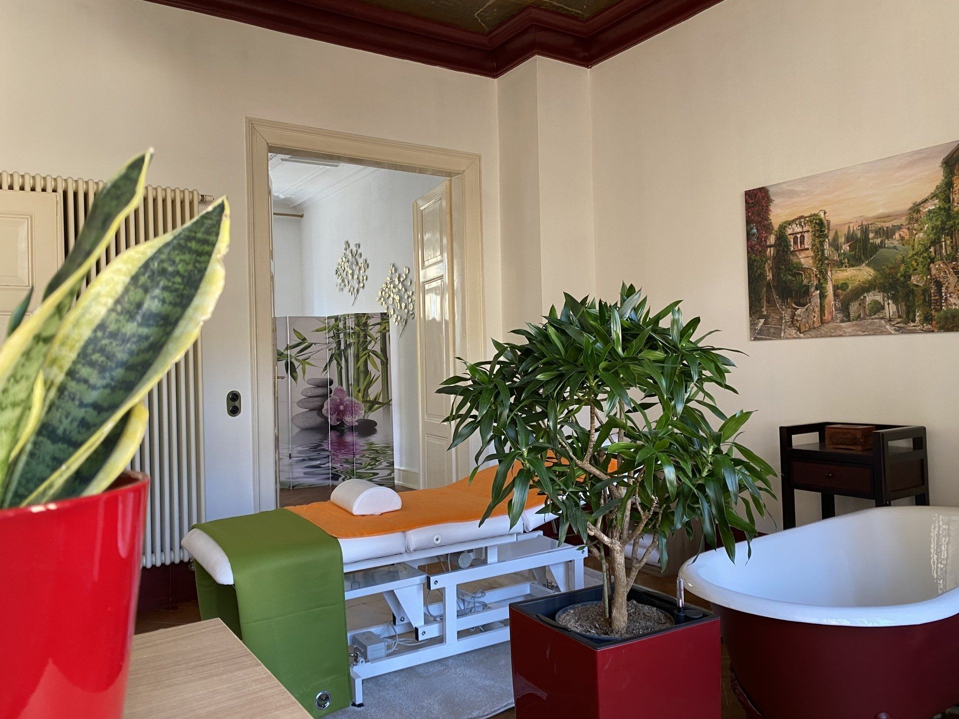 Ein Raum mit Massagetisch und Badewanne.