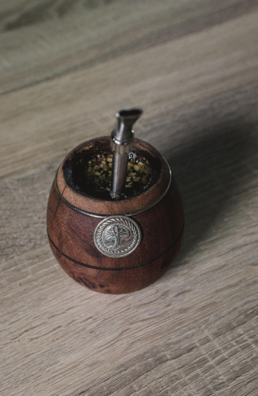 Mate de madera con bombilla de metal sobre superficie de madera.