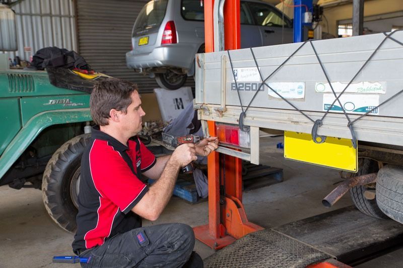 A Man Is Working On A Truck In A Garage — CS Mechanical Repairs & Services In Wauchope, NSW