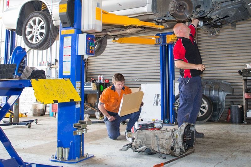Two Mechanics Are Working On A Car In A Garage — CS Mechanical Repairs & Services In Wauchope, NSW