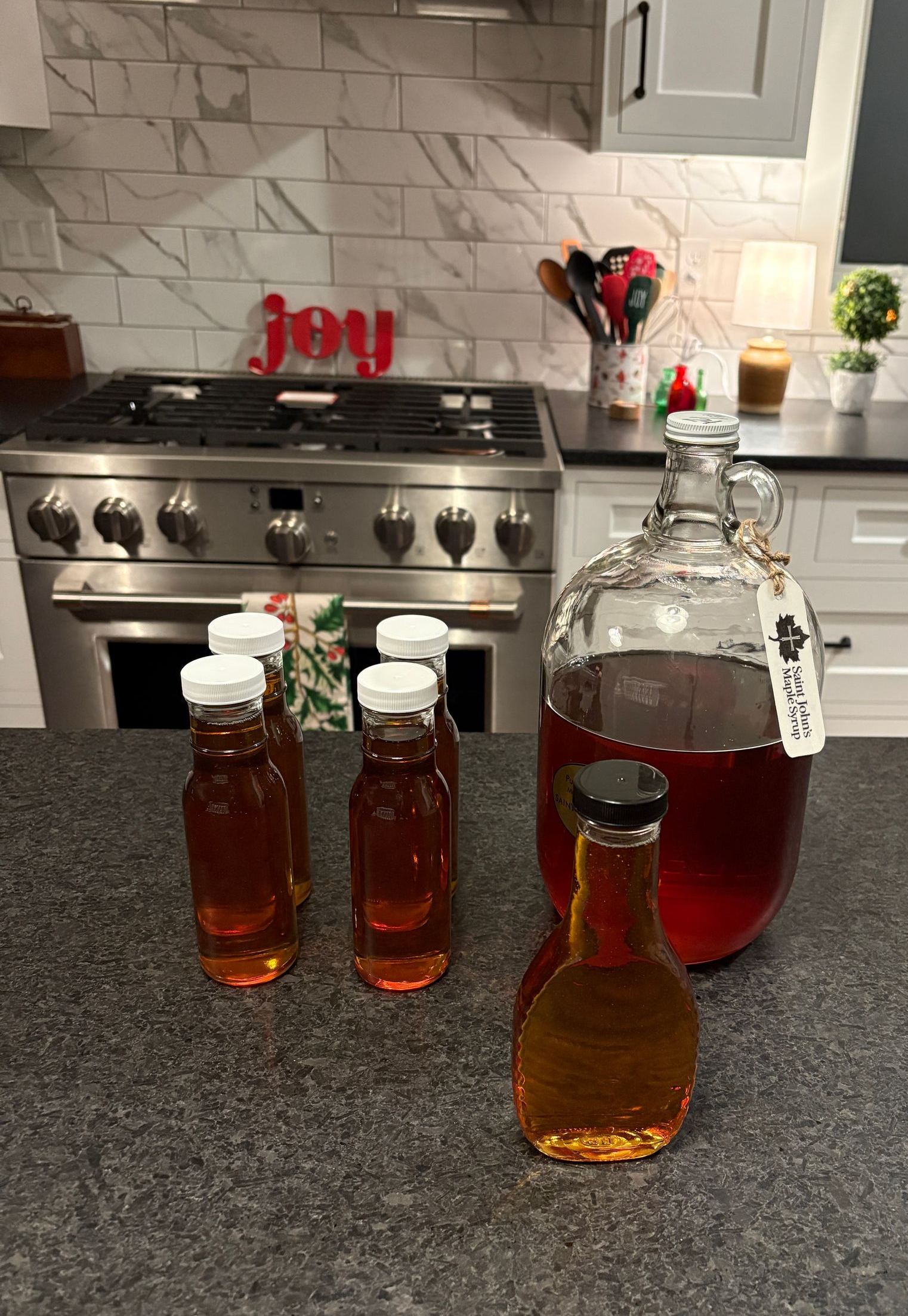 Maple syrup bottles on the counter with holiday decor.