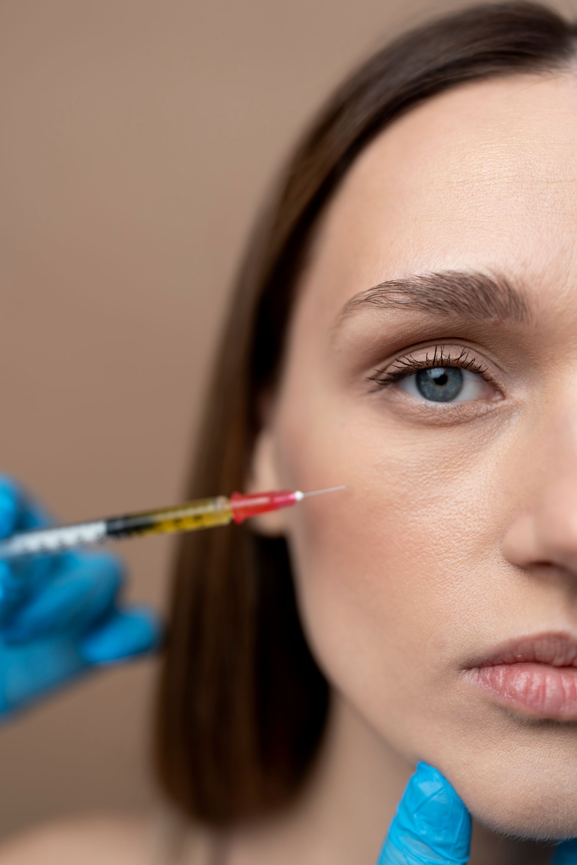 A woman is getting a botox injection in her face.