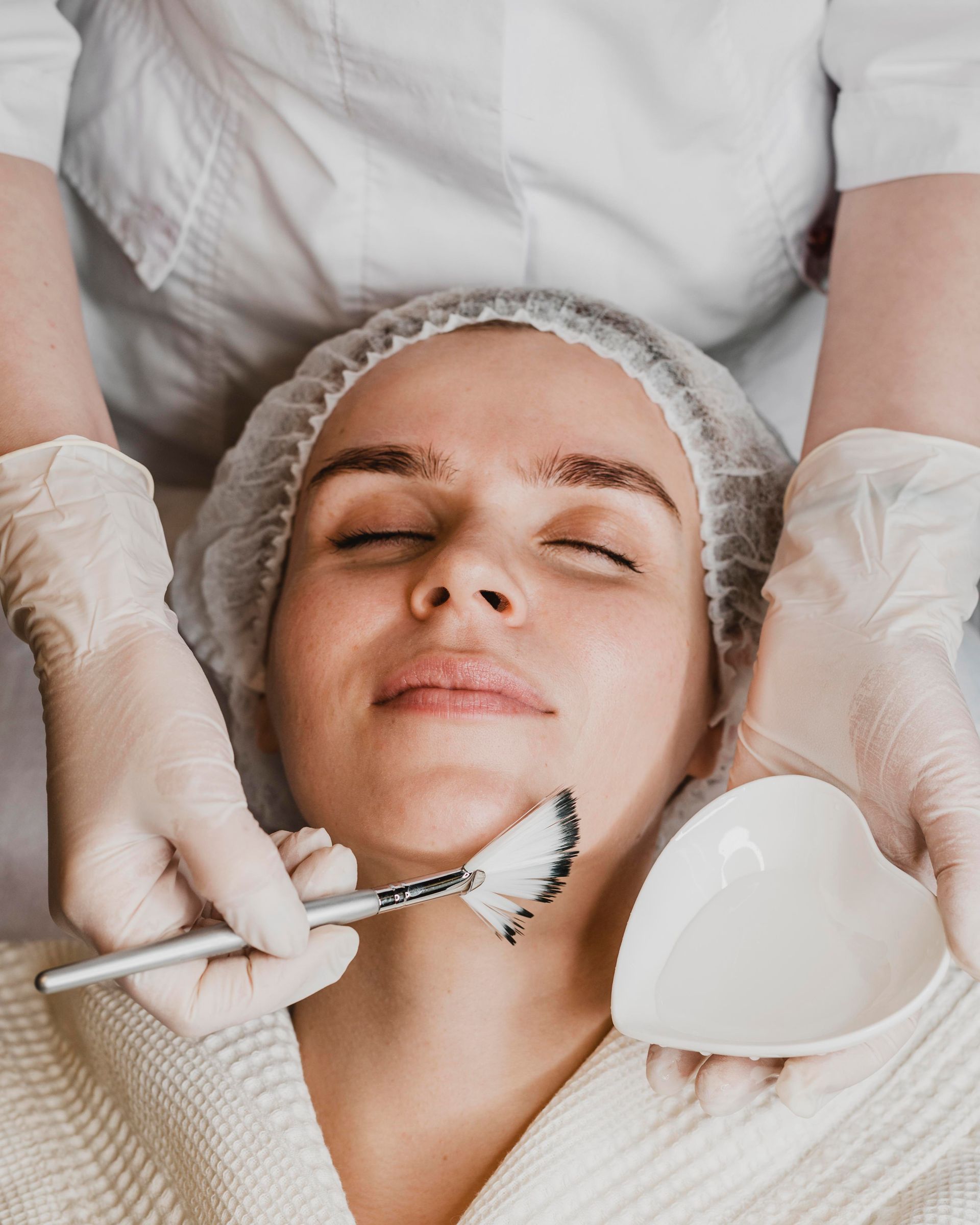 A woman is getting a facial treatment at a beauty salon.