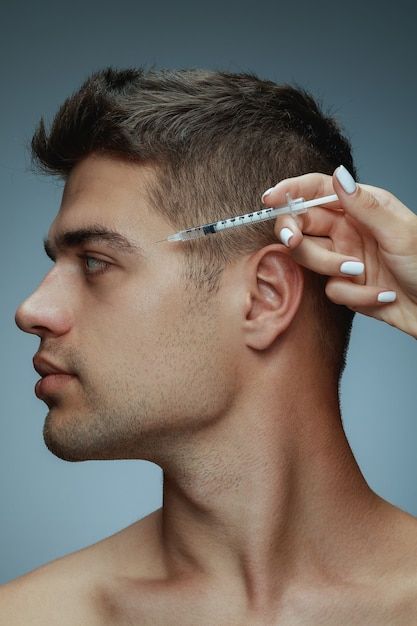 A man is getting a botox injection in his forehead.