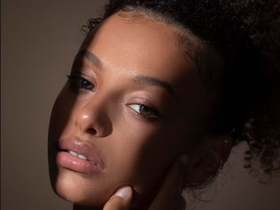 A close up of a woman 's face with a shadow on her face.