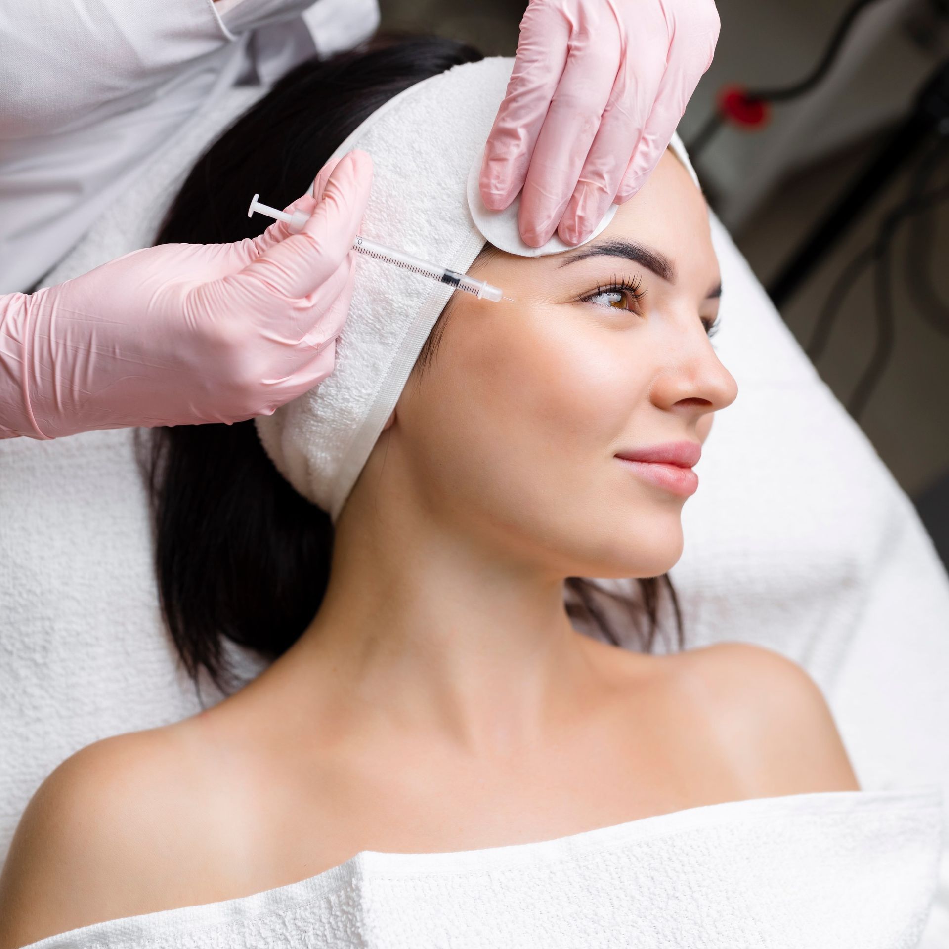 A woman is getting a botox injection in her face.