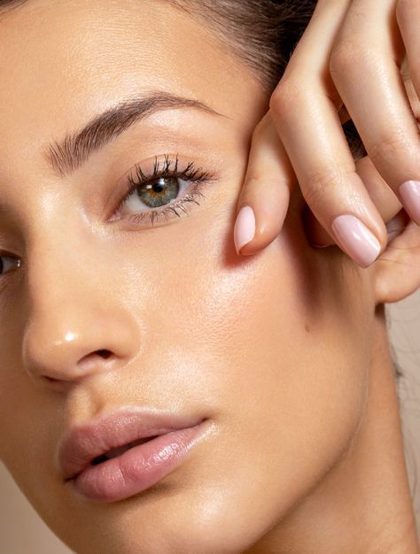 A close up of a woman 's face with her hands on it.