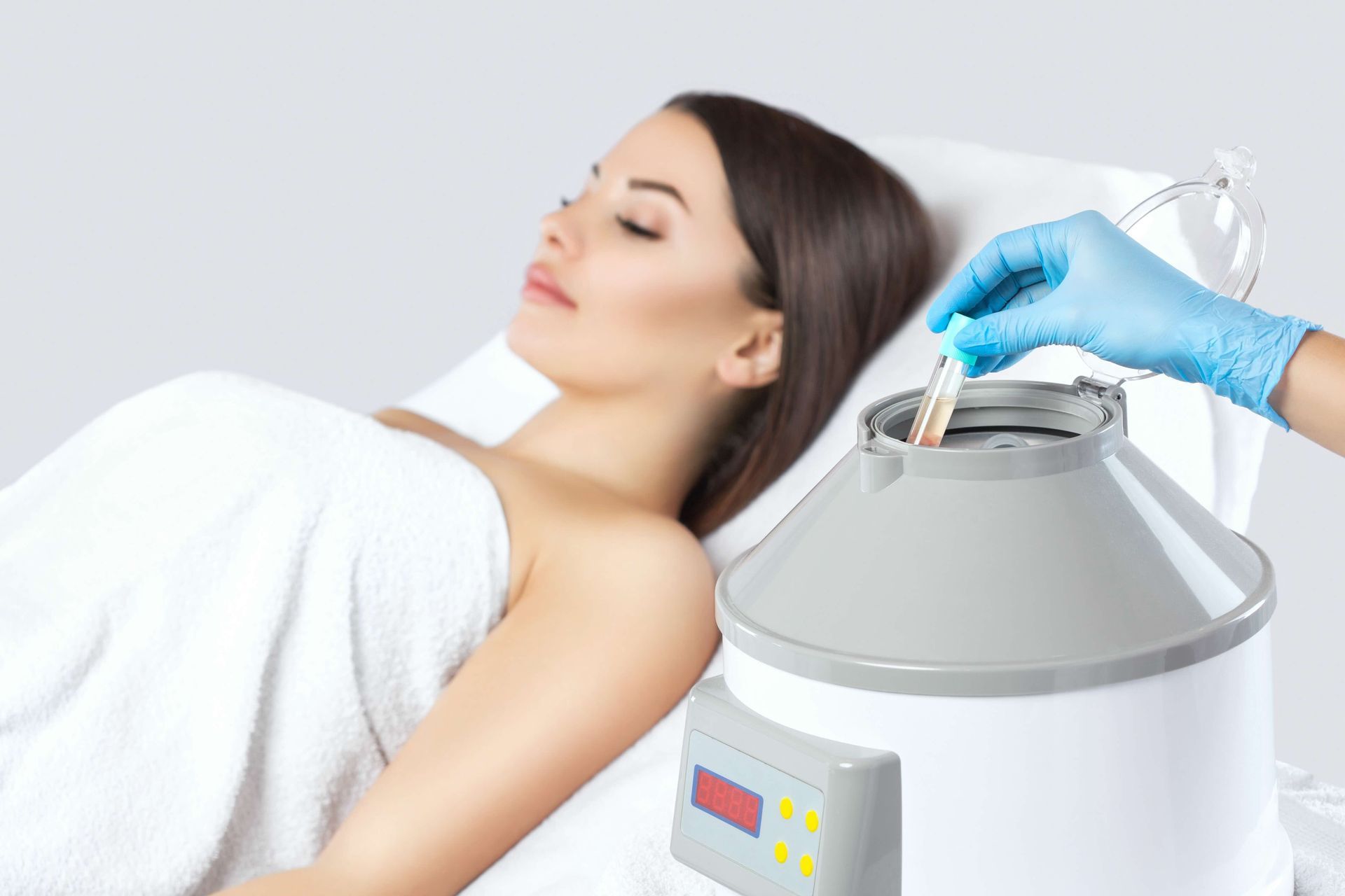 A woman is laying in a bed getting a plasma treatment.