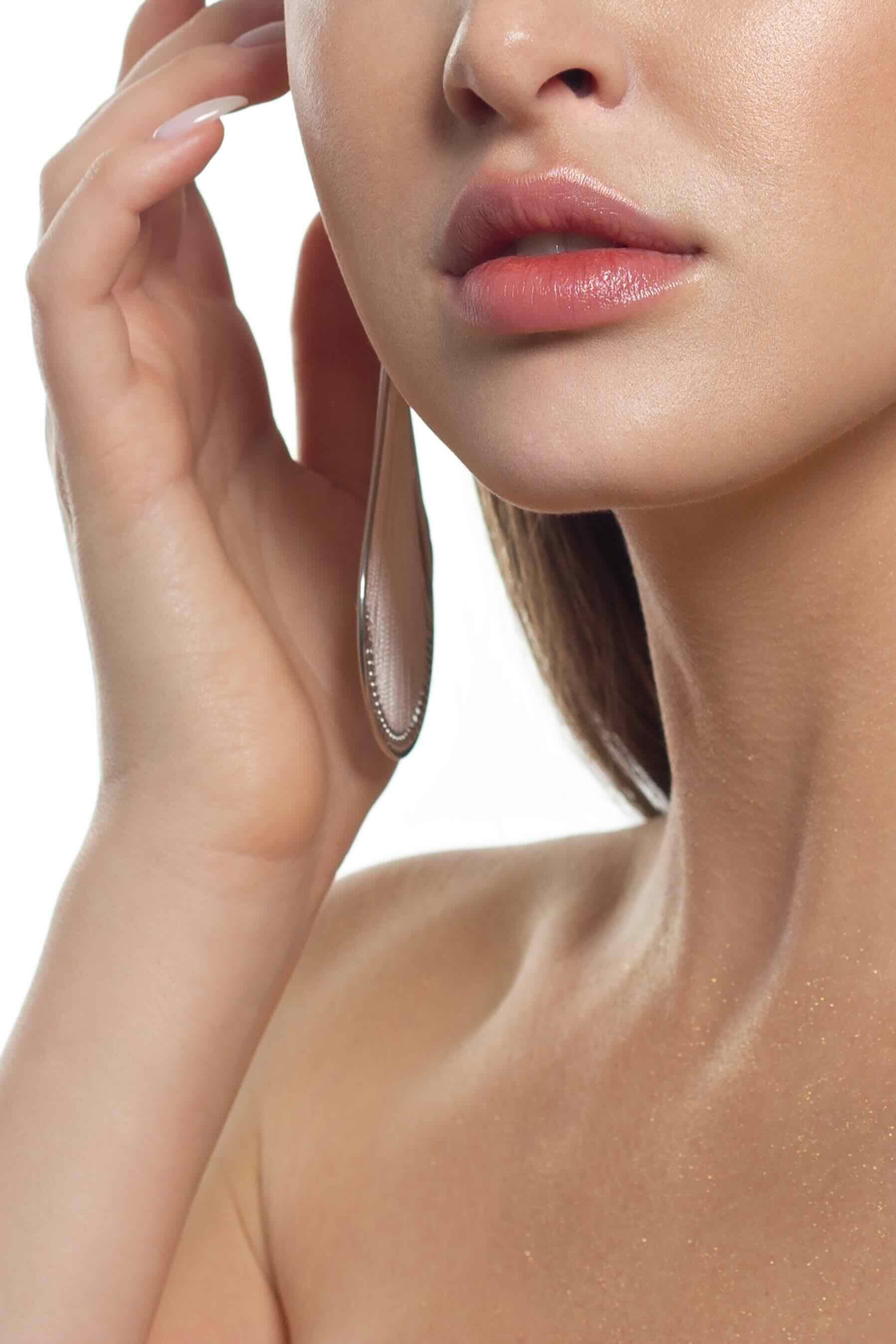 A close up of a woman 's face with her hand on her ear.