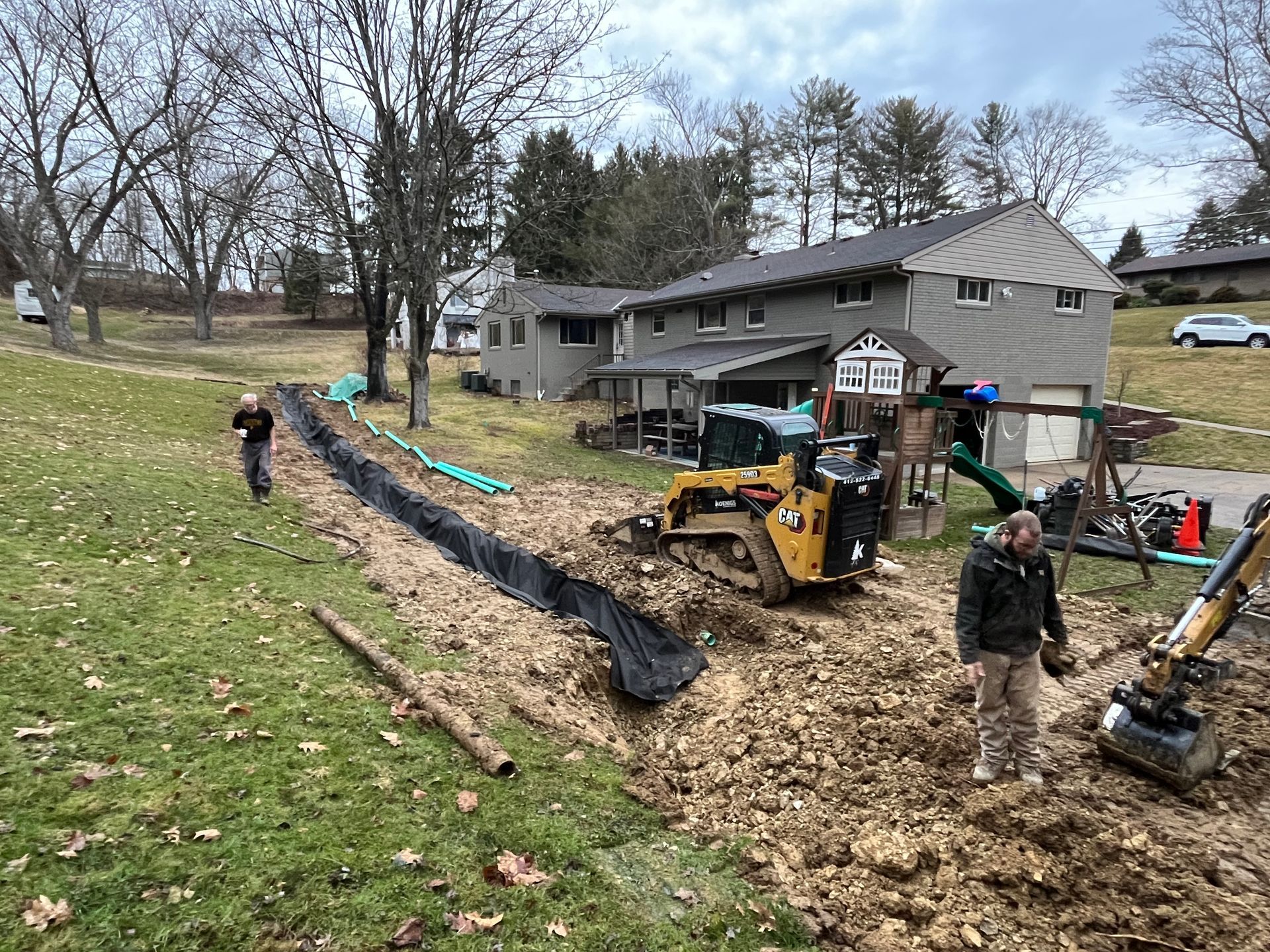 A man is standing in the dirt next to a bulldozer.