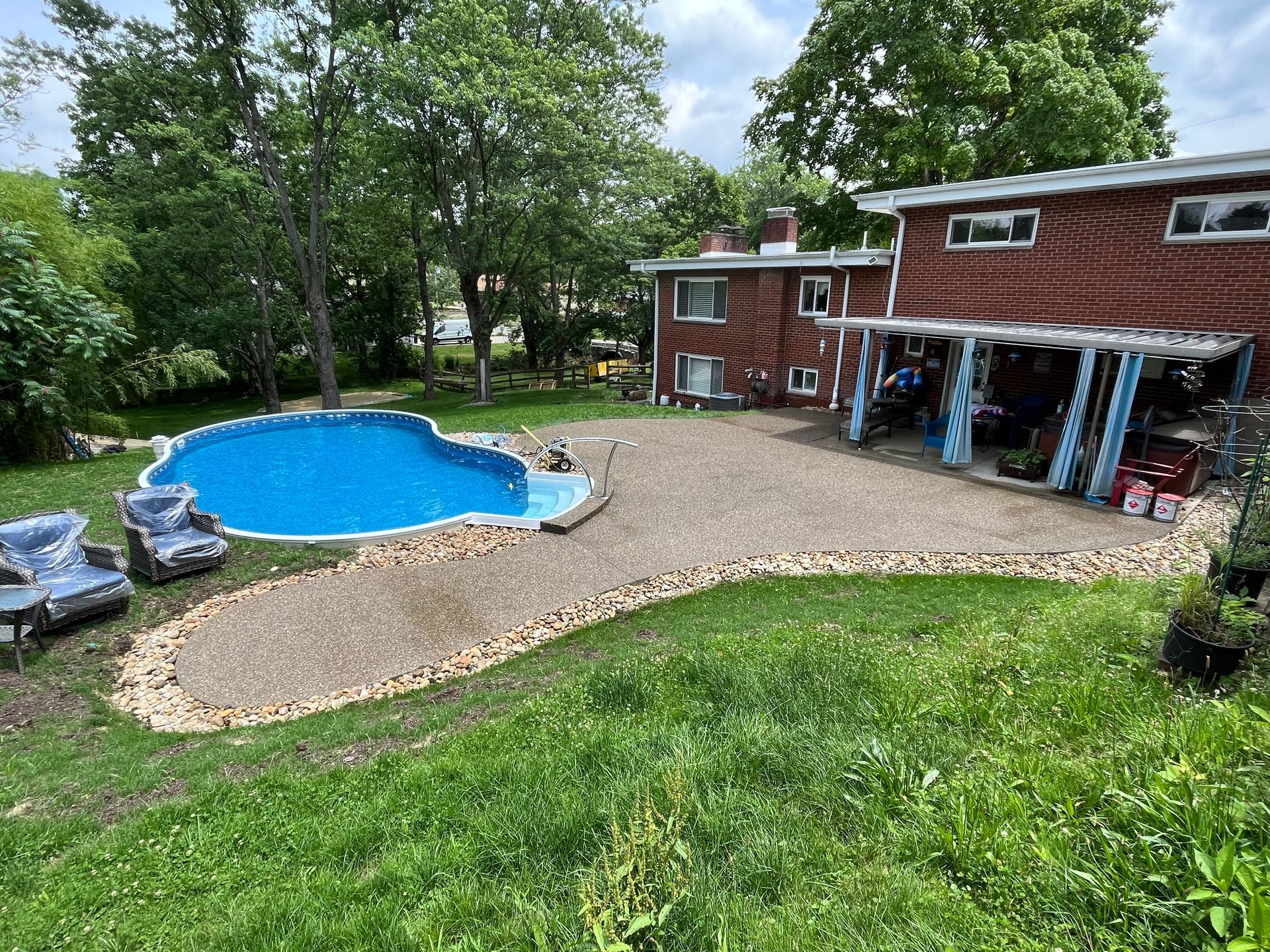 There is a large swimming pool in the backyard of a house.