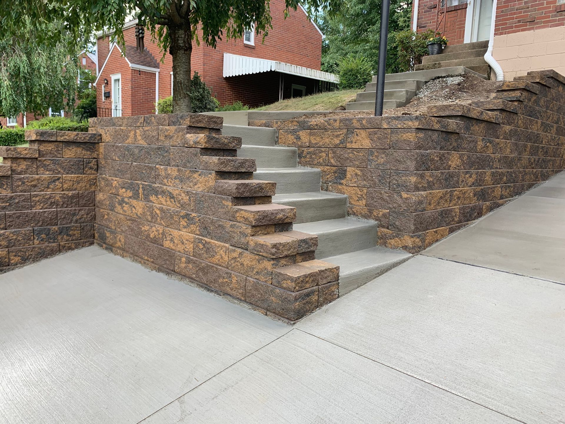 A brick wall with stairs leading up to a house.