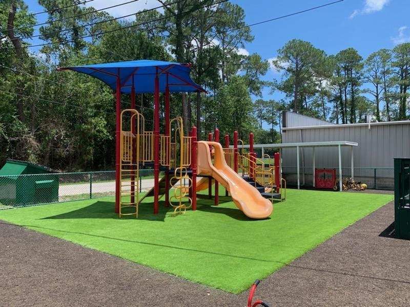 A playground with a slide and a blue canopy