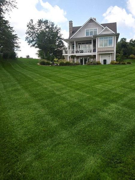 A large house with a lush green lawn in front of it.