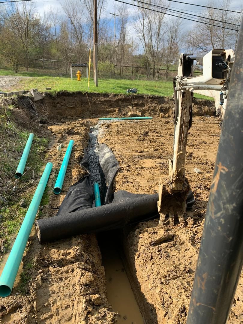 A construction site with a lot of pipes in the dirt.